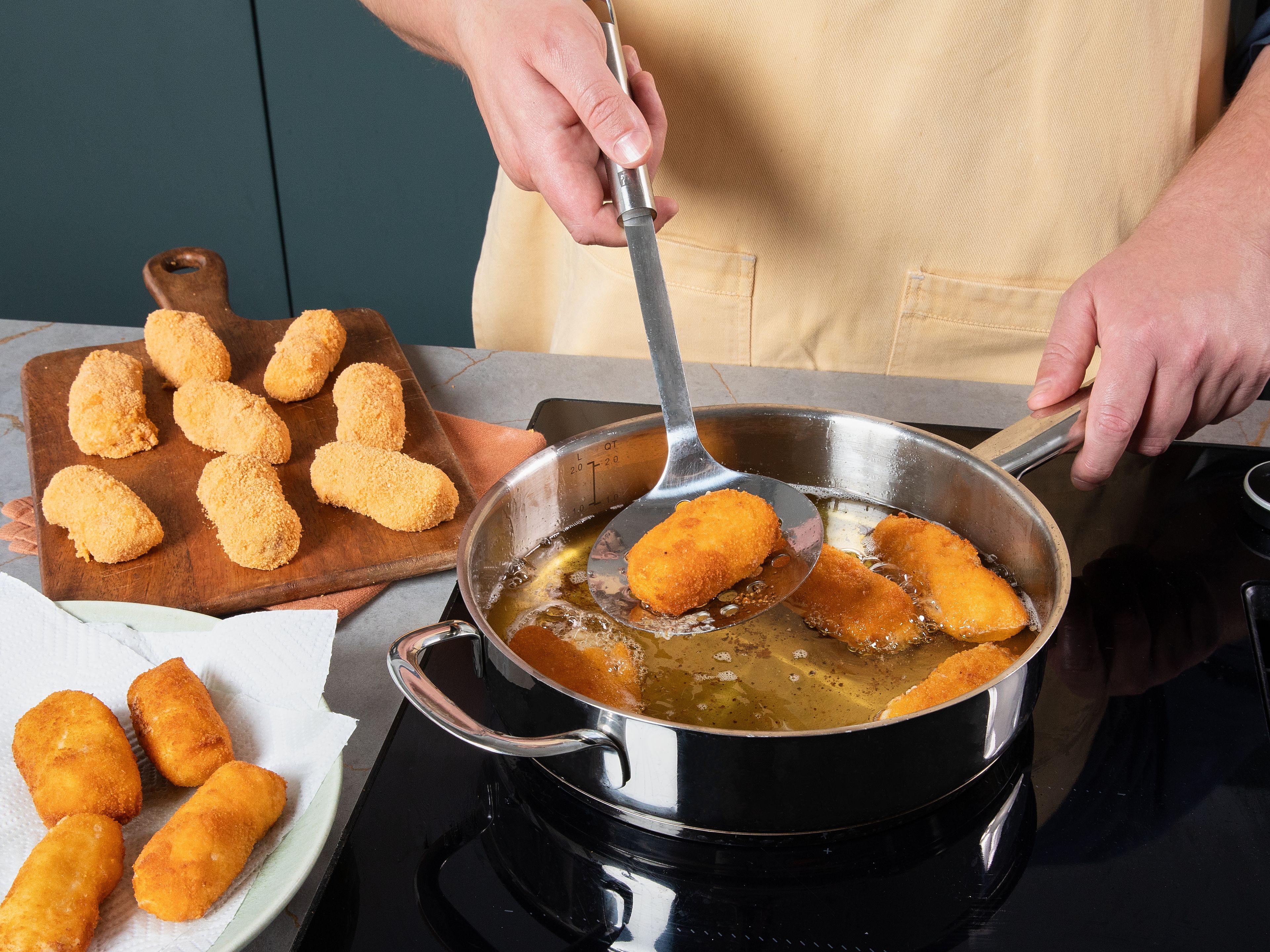 Anschließend Öl in einem Topf oder einer tiefen Pfanne erhitzen und die panierten Croquetas  darin für ca. 5 Min. goldbraun ausbacken und dabei einmal wenden. Danach auf Küchenpapier abtropfen lassen und noch warm mit etwas Aioli servieren.