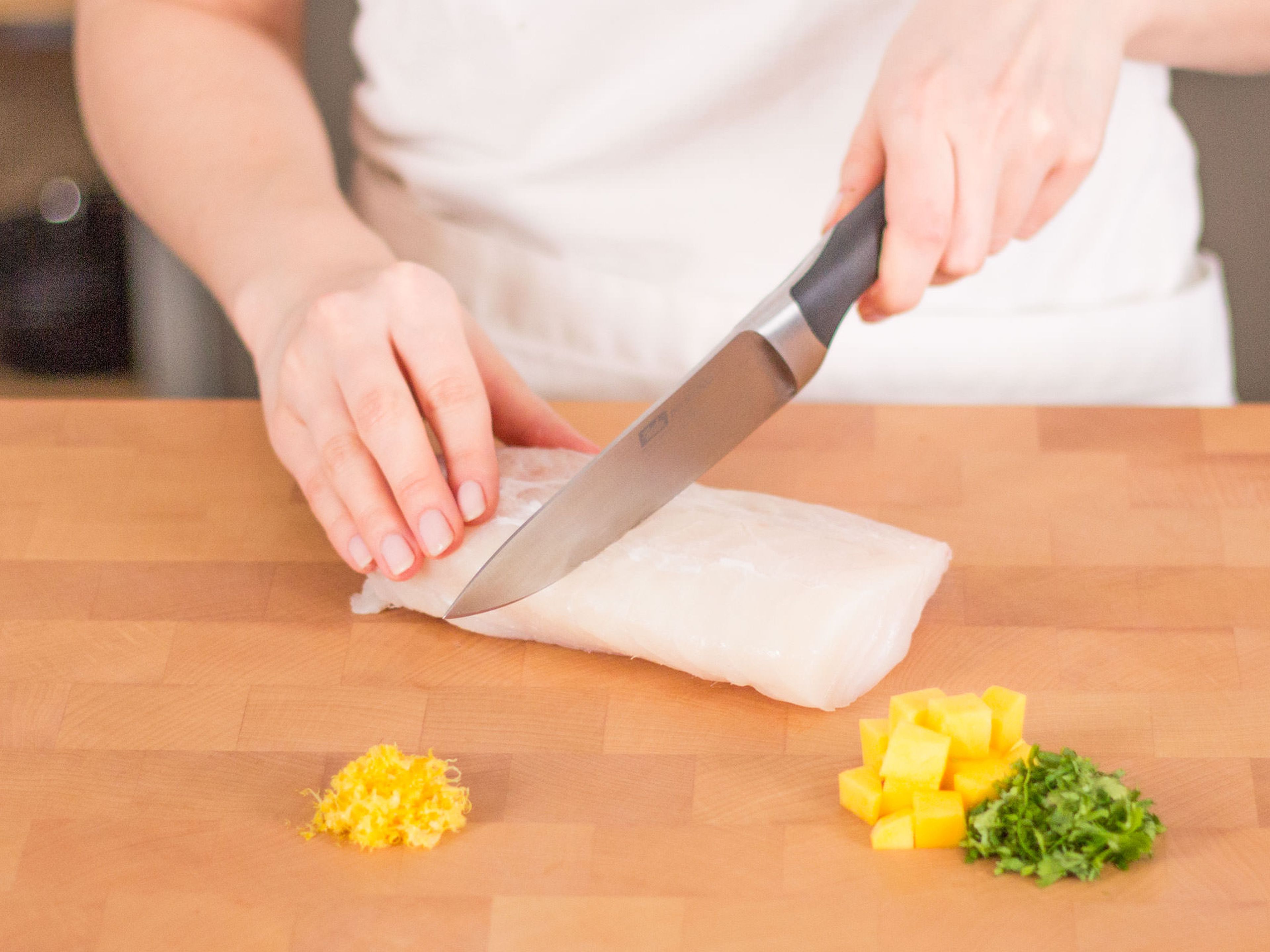 Peel and dice mango. Finely chop cilantro. Grate lemon peel and cut cod in two equal-sized fillets.