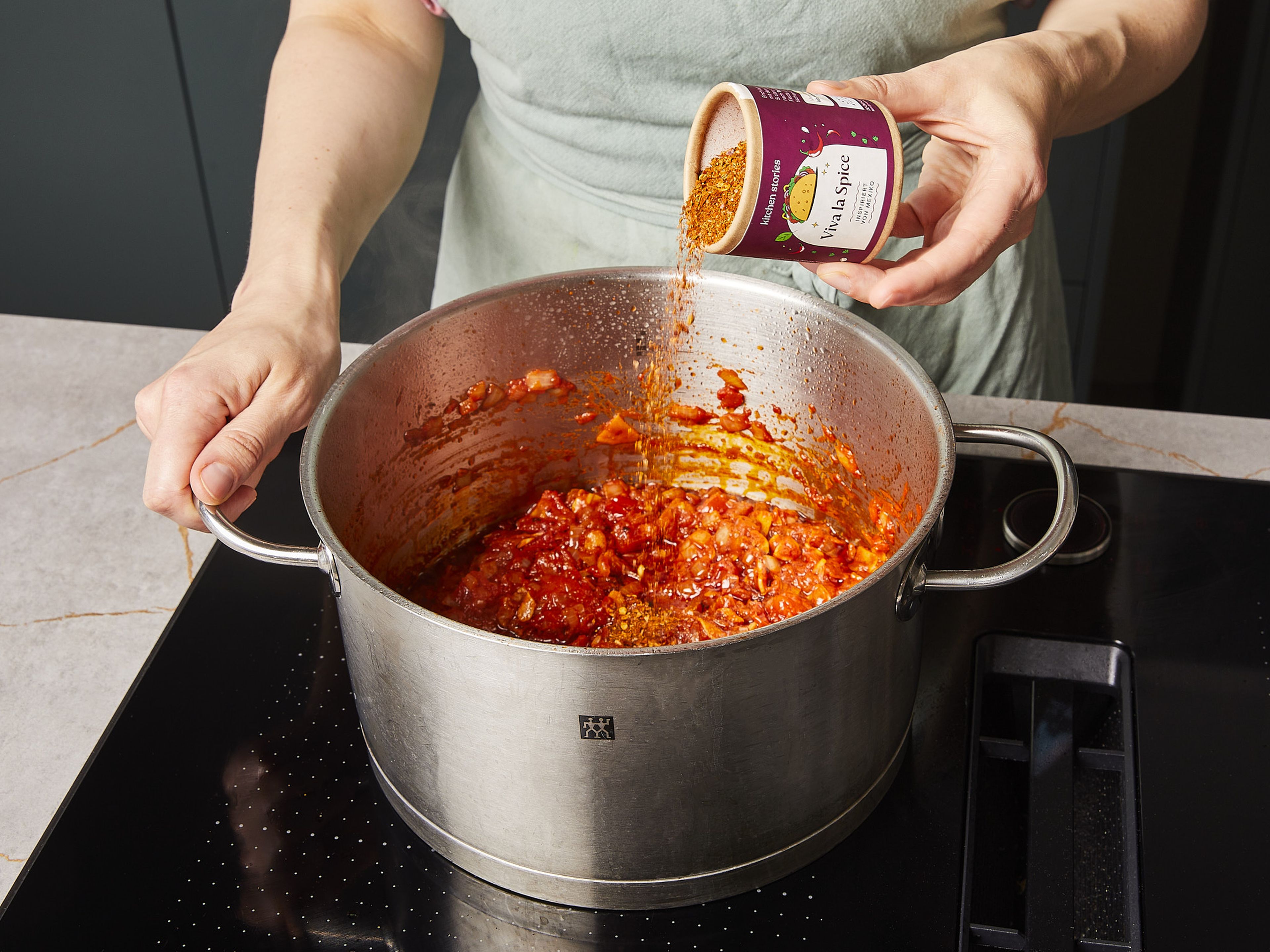 Add tomatoes and garlic, fry for approx. 2 min. Then add our VIVA LA SPICE seasoning and beef broth and mix. Add chicken pieces back to the pot, bring to a boil and simmer over medium-high heat for approx. 25–30 min. Meanwhile, chop cilantro. Cut limes into wedges.