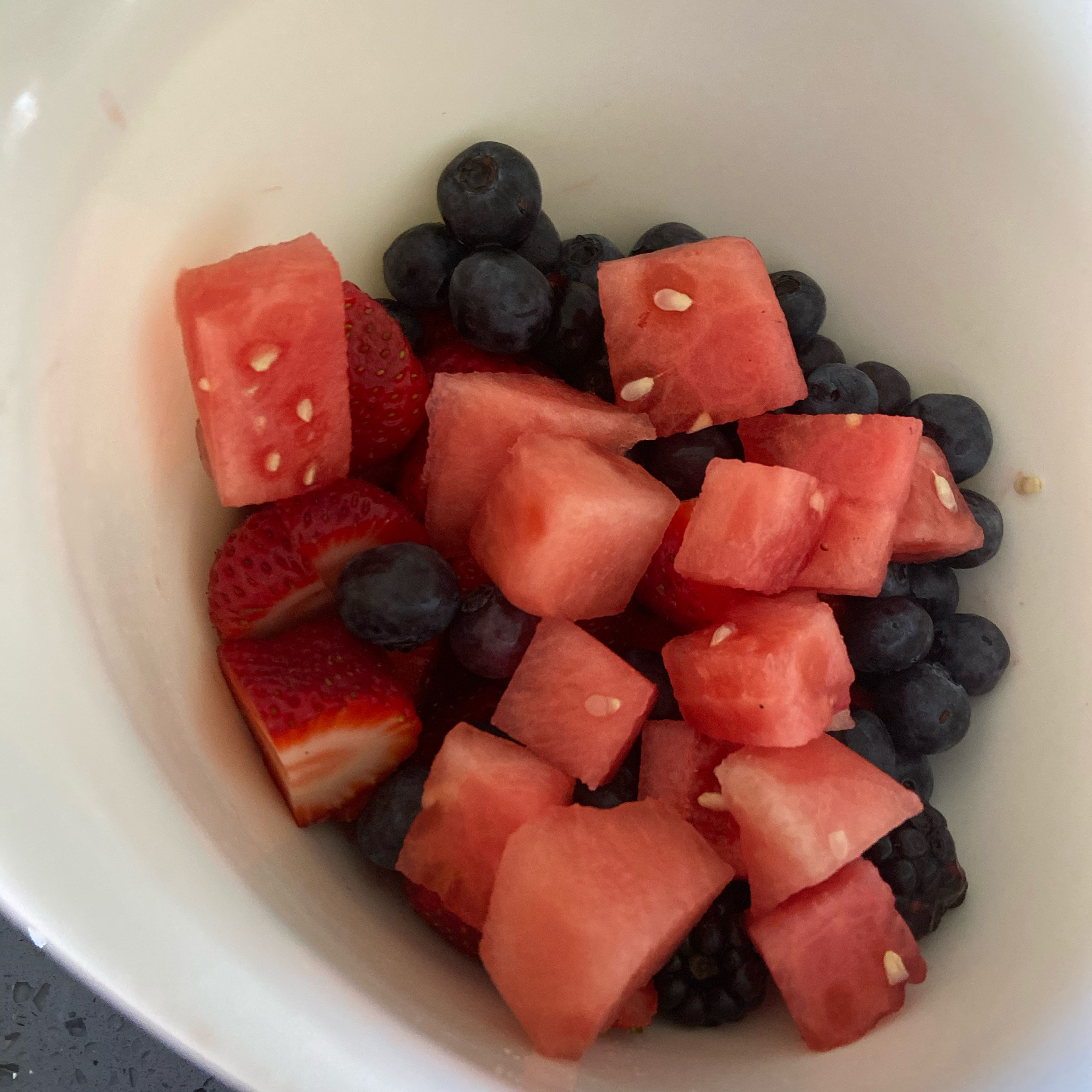 Put the watermelon in the bowl with the strawberries,blueberries,and raspberries