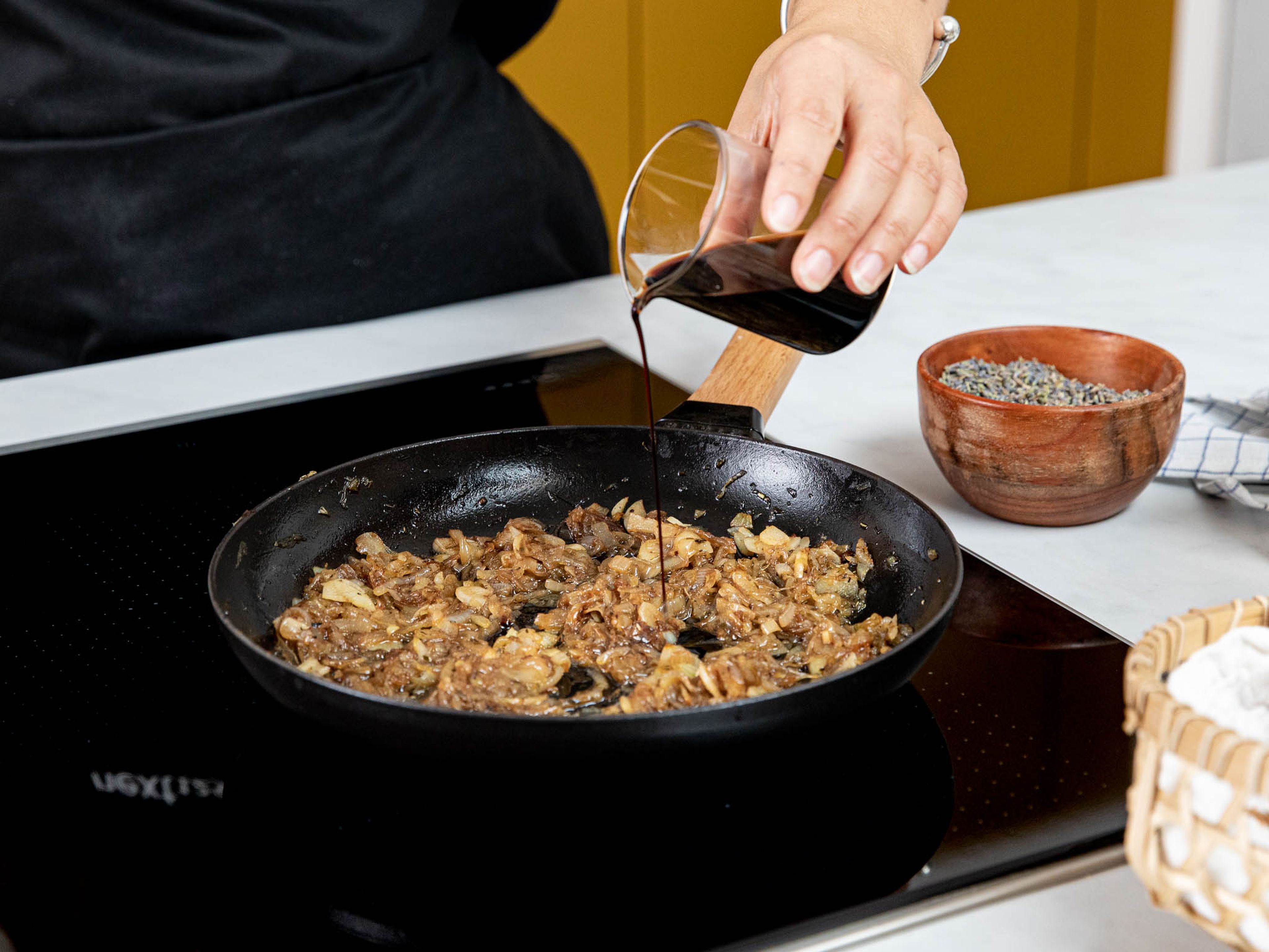 Zwiebeln und Knoblauchzehen in sehr dünne Scheiben schneiden. Eine großzügige Menge Olivenöl in einer Pfanne über mittlerer Hitze erwärmen und die Zwiebeln darin sanft anschwitzen, bis sie glasig sind. Knoblauch dazugeben und weiter anschwitzen, bis die Zwiebeln weich und karamellisiert sind. Balsamicoessig dazugeben und mit Salz und Kräutern der Provence würzen. Anschließend beiseitestellen.