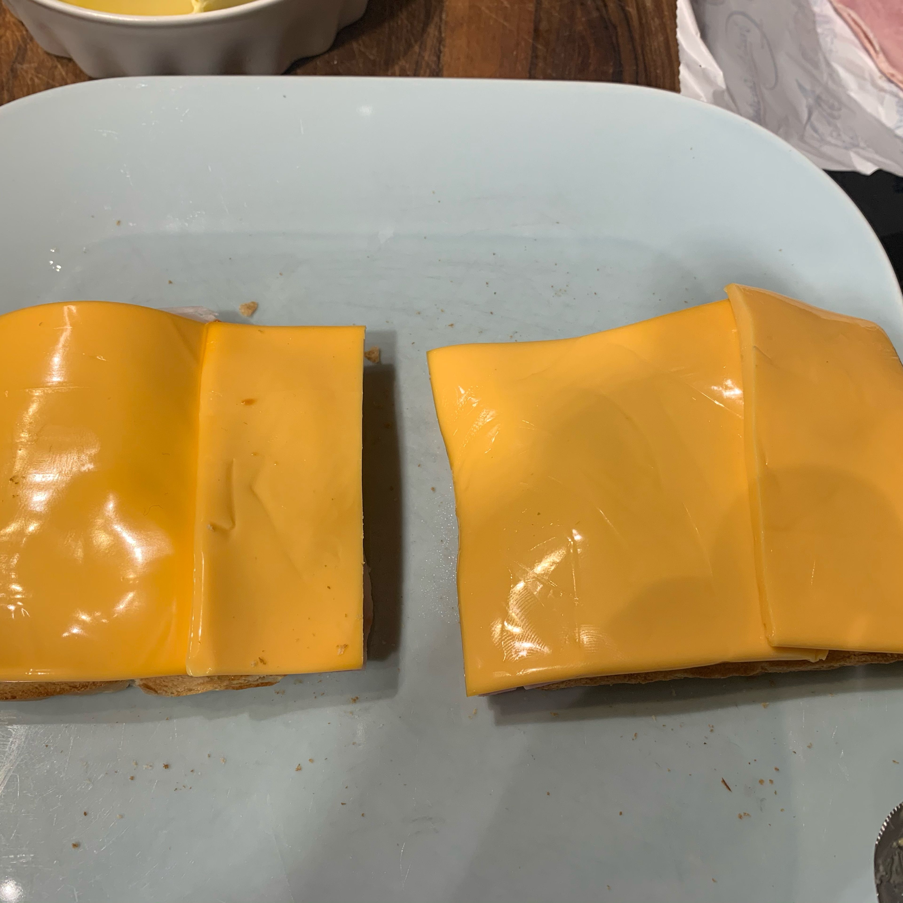 Den Schmelzkäse so verteilen das alles gut bedeckt ist. Meistens braucht man dazu 1 1/2 Scheiben. Den Käse nicht aus der Packung nehmen sondern frisch von der Käsetheke kaufen, schmeckt besser und man hat genau die Menge die man braucht.
