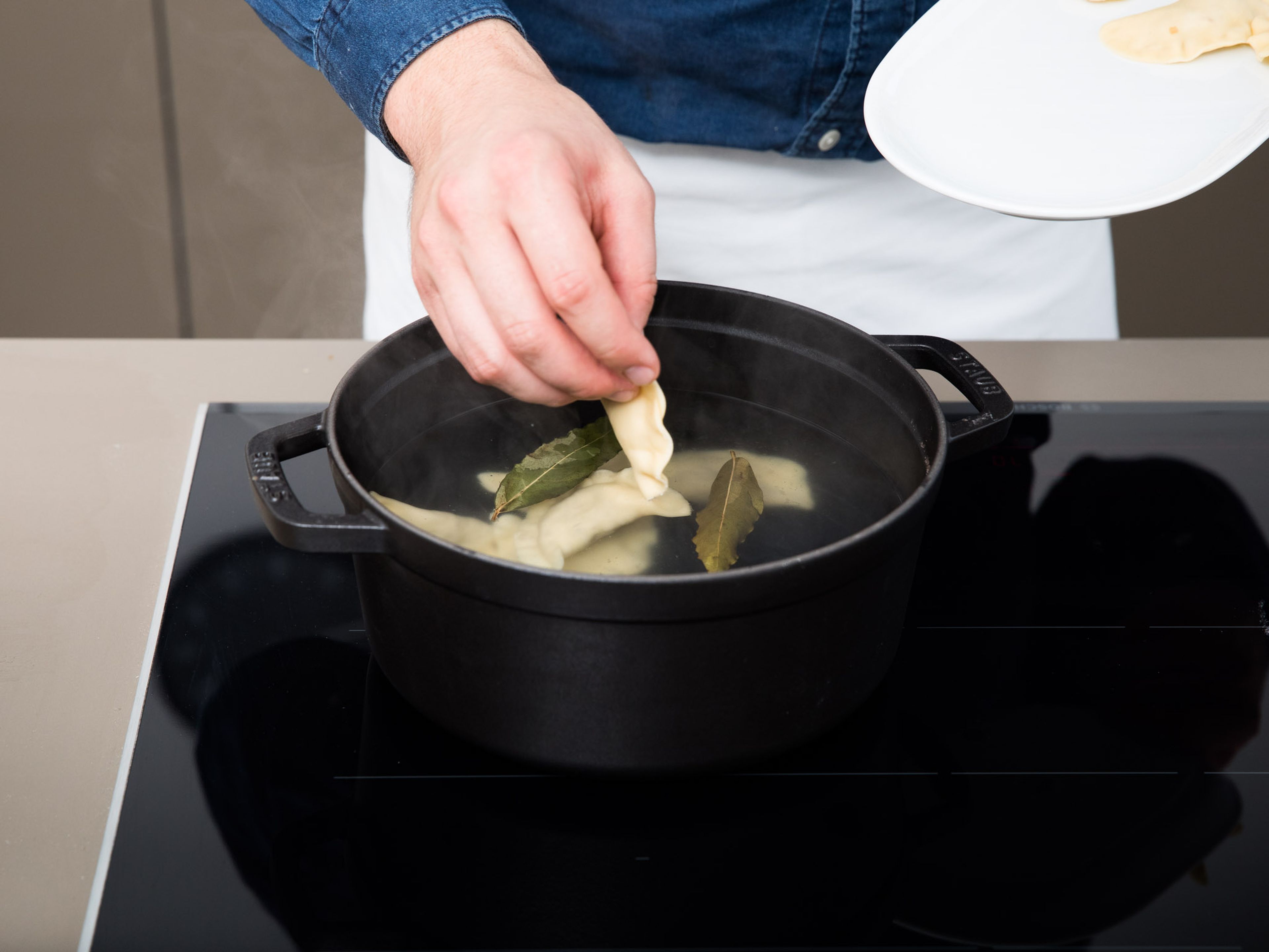 Bring salted water to a boil in a large pot, add bay leaves and carefully slip in the pierogi. Let cook at a rolling boil for approx. 3 – 4 min. Remove from the pot using a slotted spoon.
