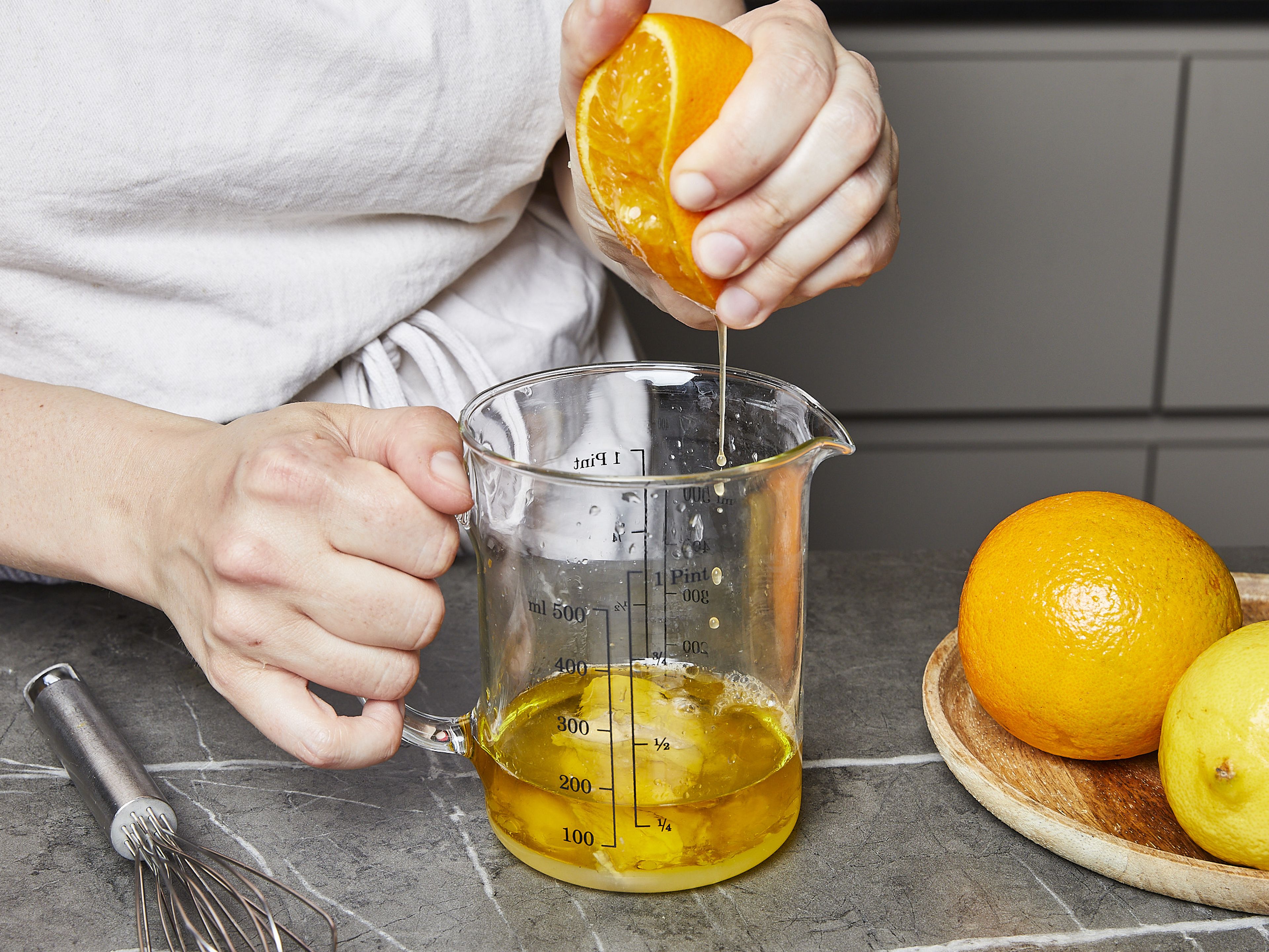 Für die Vinaigrette Olivenöl, Senf, Zitronensaft und den restlichen Orangensaft miteinander vermengen. Mit Salz und Pfeffer abschmecken.
