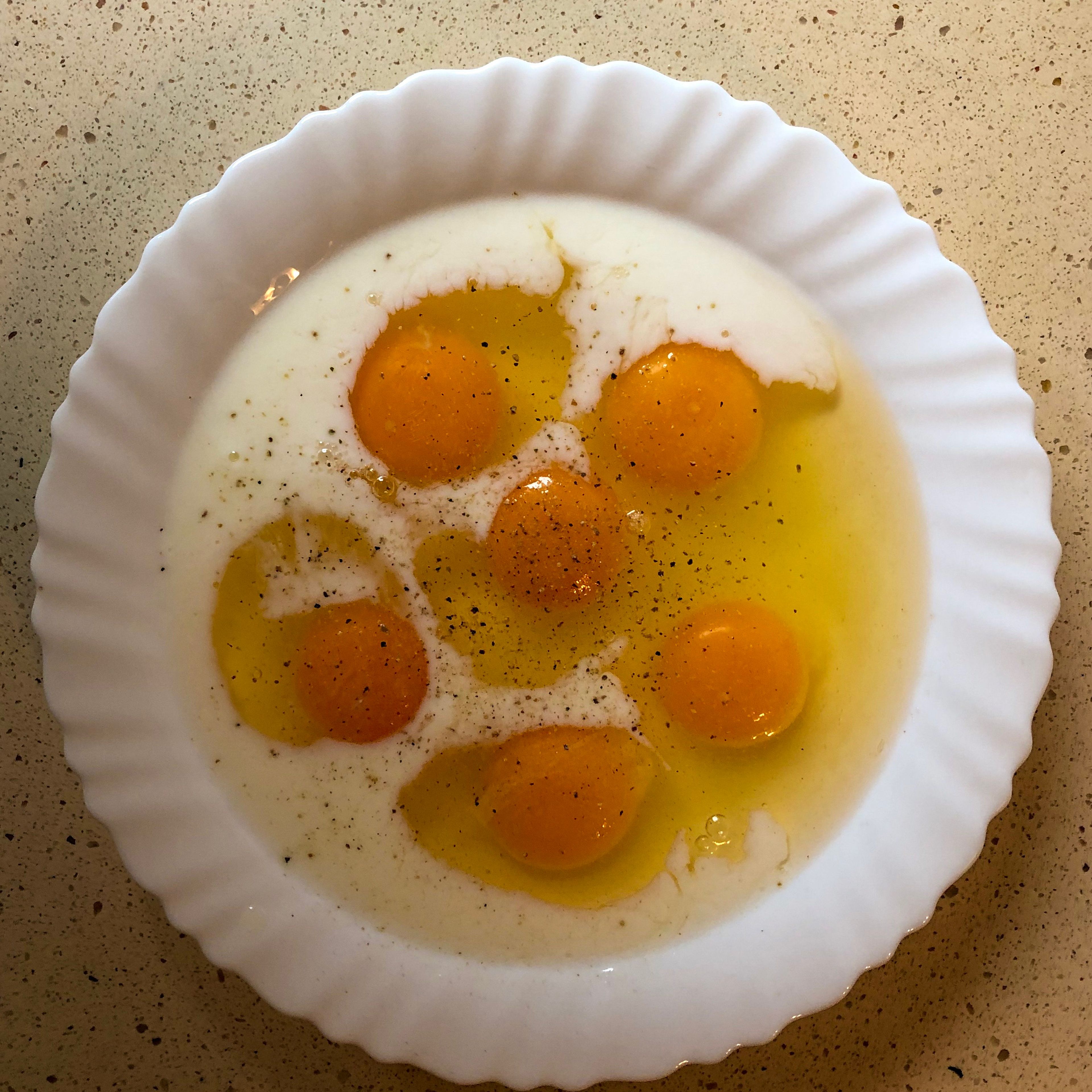 Grab a bowl, crack open your eggs and add the egg white and yolks into the bowl. Add milk, salt and pepper for seasoning. Whisk until all mixed.