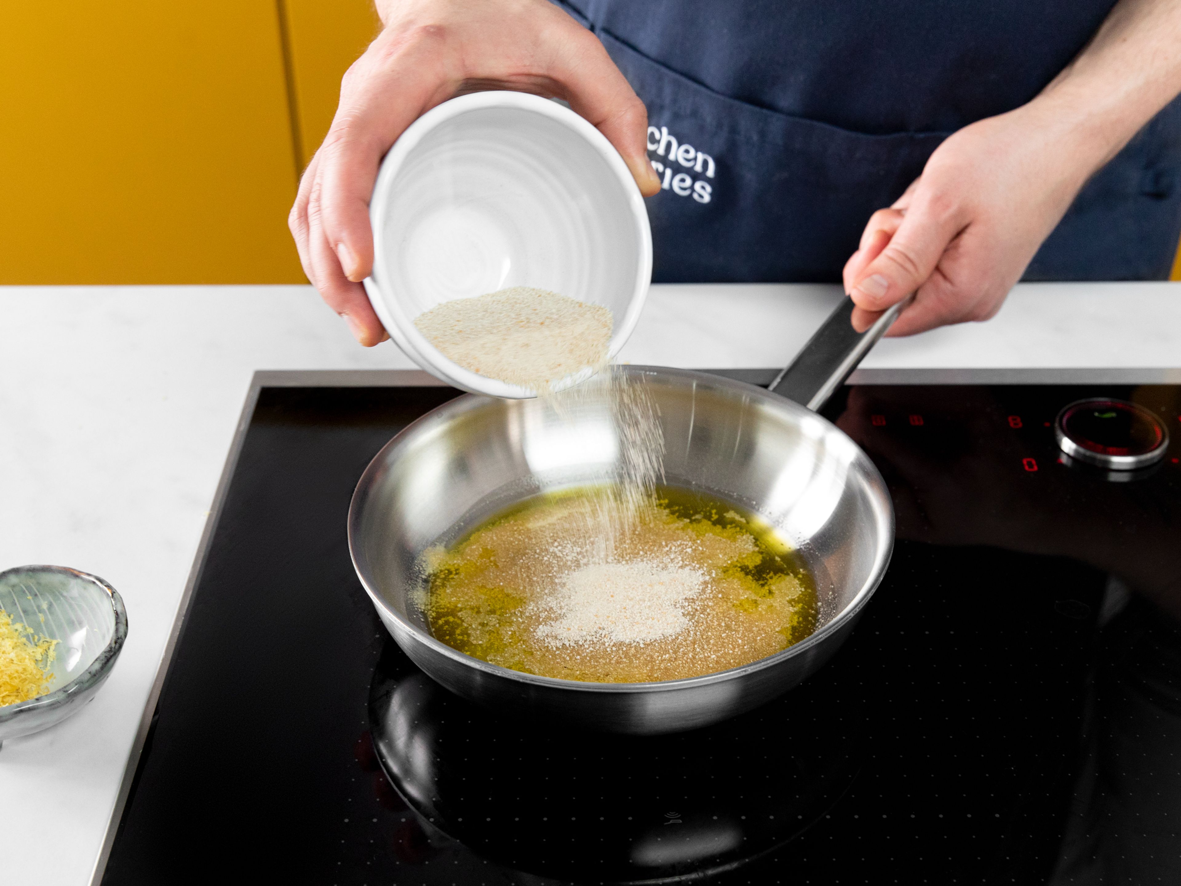 Heat remaining olive oil in a separate frying pan over medium heat. Add breadcrumbs and toast until golden brown. Remove from heat and add lemon zest.