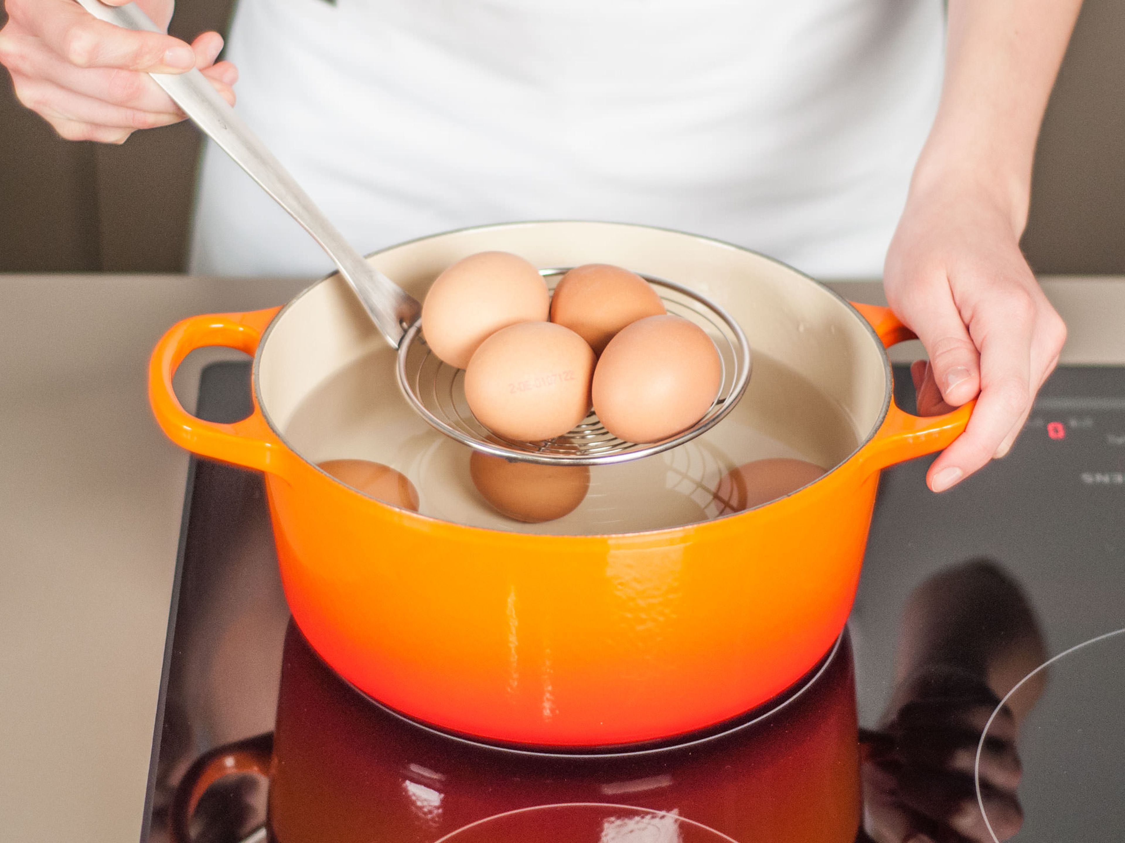 Zwei Drittel der Eier in einen Topf geben und mit kaltem Wasser bedecken. Zum Kochen bringen und ca. 7 – 8 Min. garen. Aus dem Topf nehmen und sofort in ein Eisbad legen oder unter kaltem Wasser abschrecken. Eier schälen, sobald sie kalt genug zum Anfassen sind.