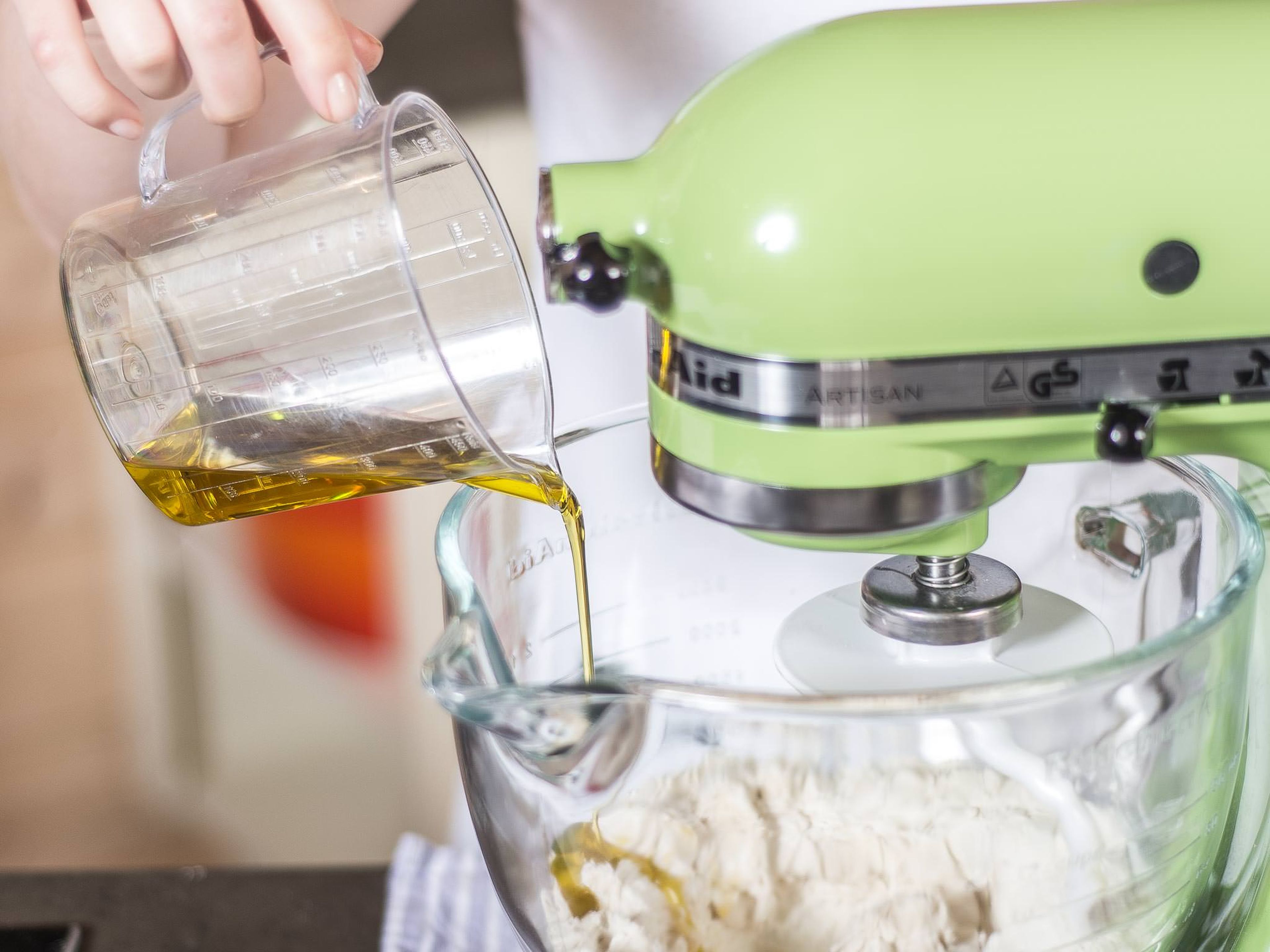 Mehl, Wasser, Hefe, Zucker, Salz und Olivenöl in einer Küchenmaschine oder wahlweise mit den Händen zu einem geschmeidigen Teig kneten.