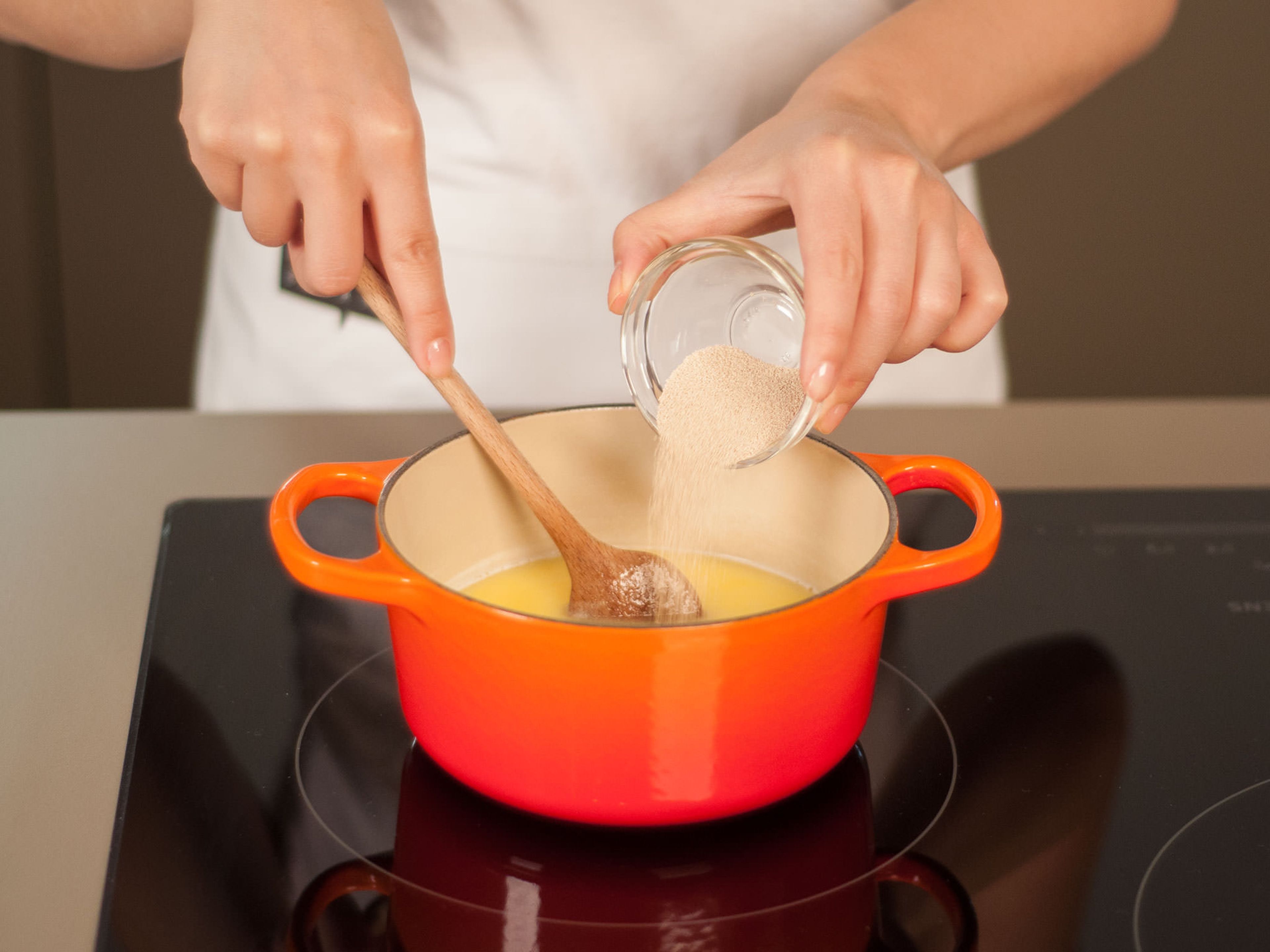 Milch in einem kleinen Topf auf mittlerer Hitze erwärmen. Butter hinzugeben und langsam schmelzen lassen. Vom Herd nehmen, abkühlen lassen, bis sie gerade noch warm ist, und nach und nach den Zucker und die Trockenbackhefe hinzufügen. Umrühren, um sie zu verbinden.
