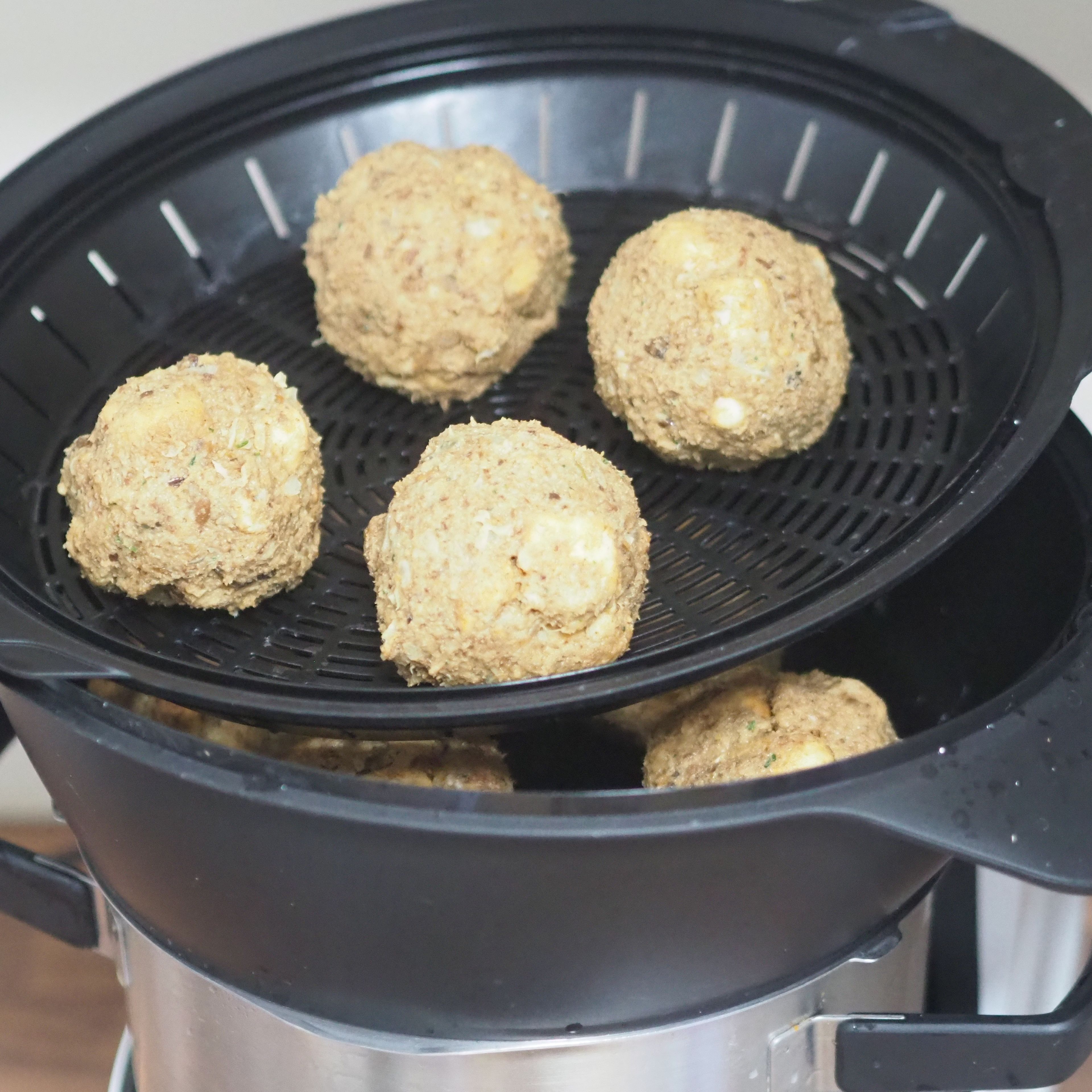 Den Cookit reinigen und bis zur Dampfmarkierung mit Wasser befüllen. Den Dampfgarprozess starten und die Semmelknödel für 20 Min. gar dämpfen.