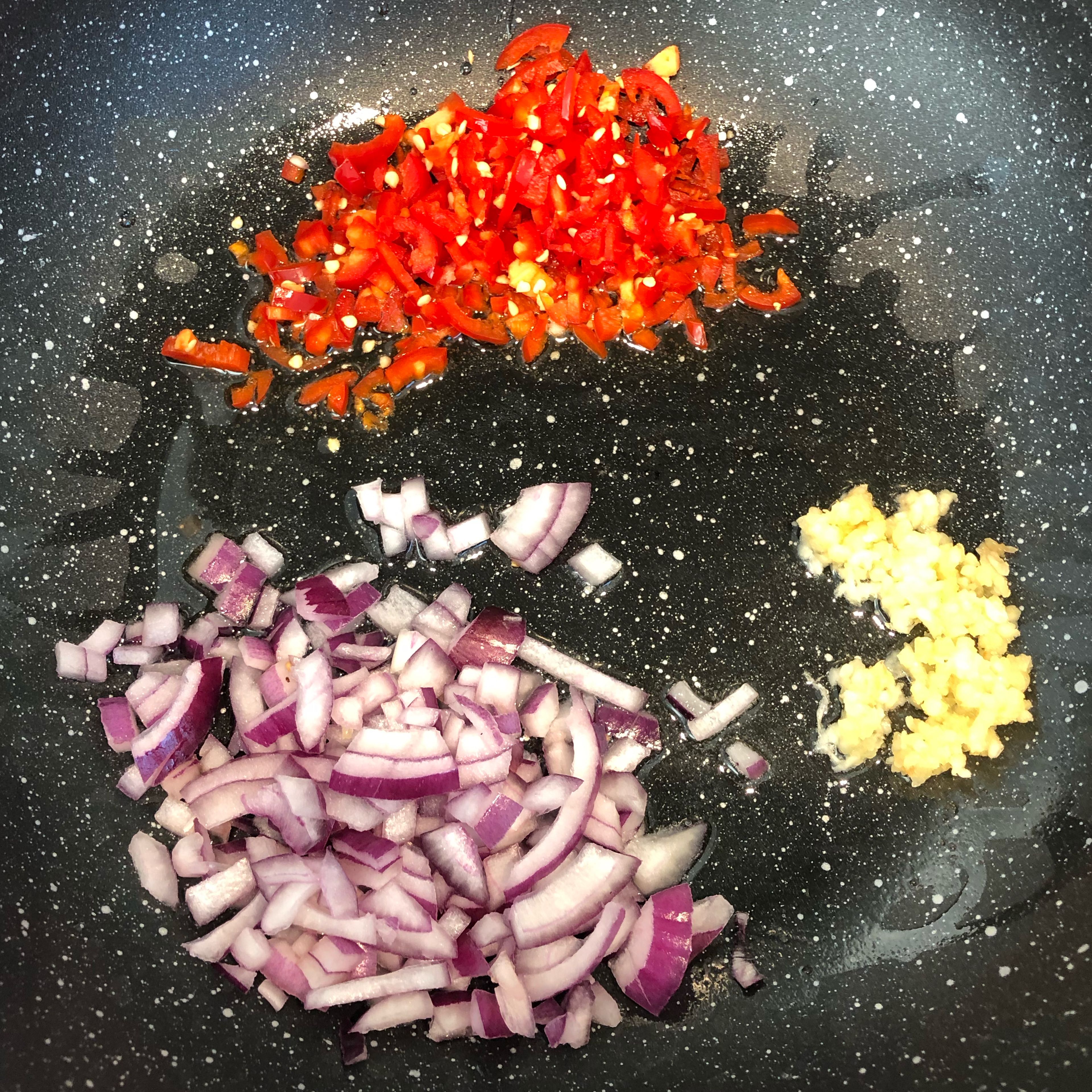 Add 25ml olive oil in pan and add garlic, onion and red pointed pepper. Stir vegetables on medium to high heat.