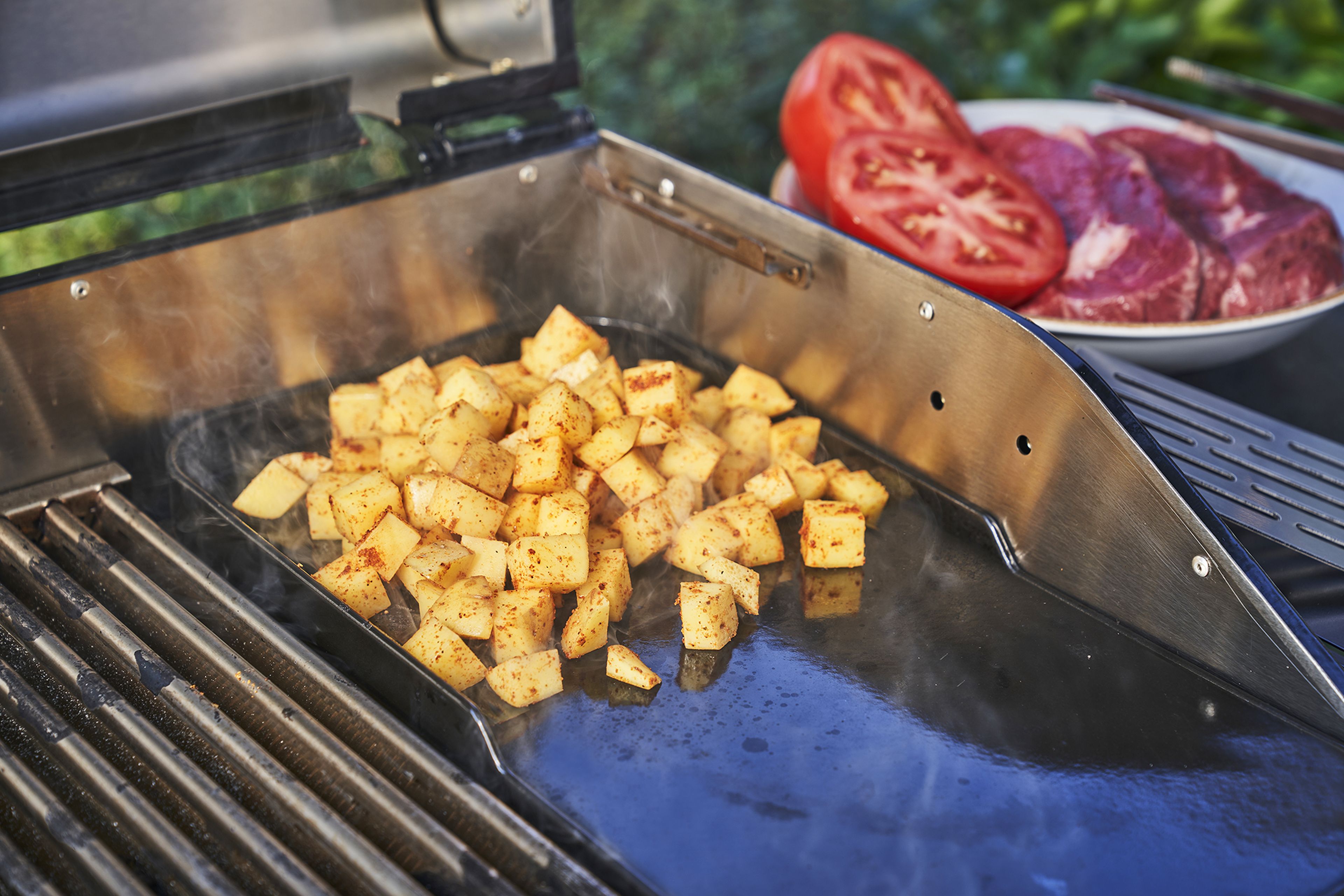Die Steaks leicht salzen und dann ab auf die vorgeheizten Grillroste damit. Sie sollten von jeder Seite ca. 4-6 Minuten gegrillt werden. Eine Tomate halbieren und ebenfalls leicht angrillen. Währenddessen die Kartoffelwürfel mit etwas Olivenöl auf die Grillplatte geben.