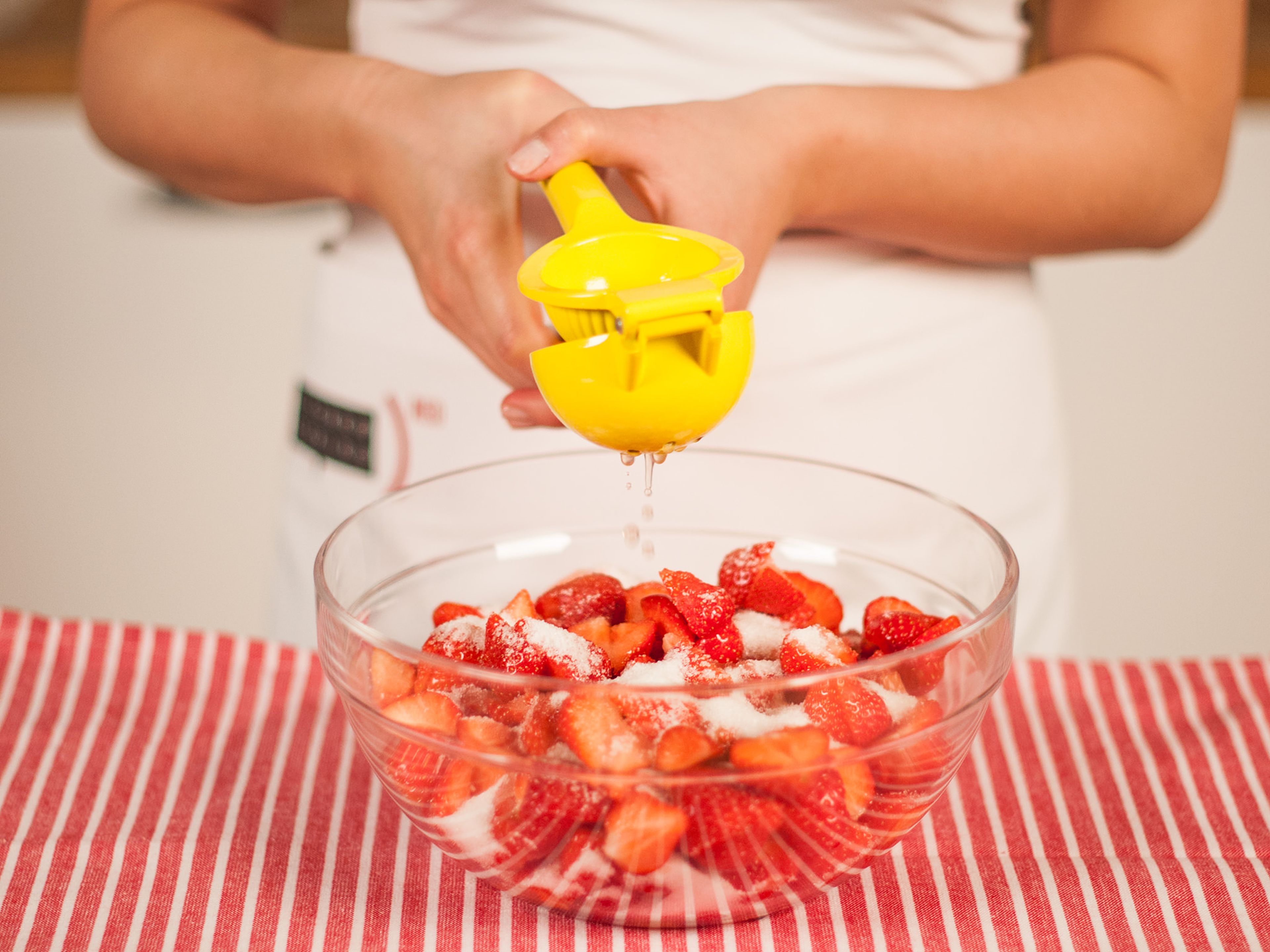 In der Zwischenzeit die Erdbeeren vom Strunk befreien und halbieren. Mit einem Teil des Zuckers, Zitronensaft und Salz marinieren und ca. 1 h ziehen lassen. Gelegentlich umrühren.