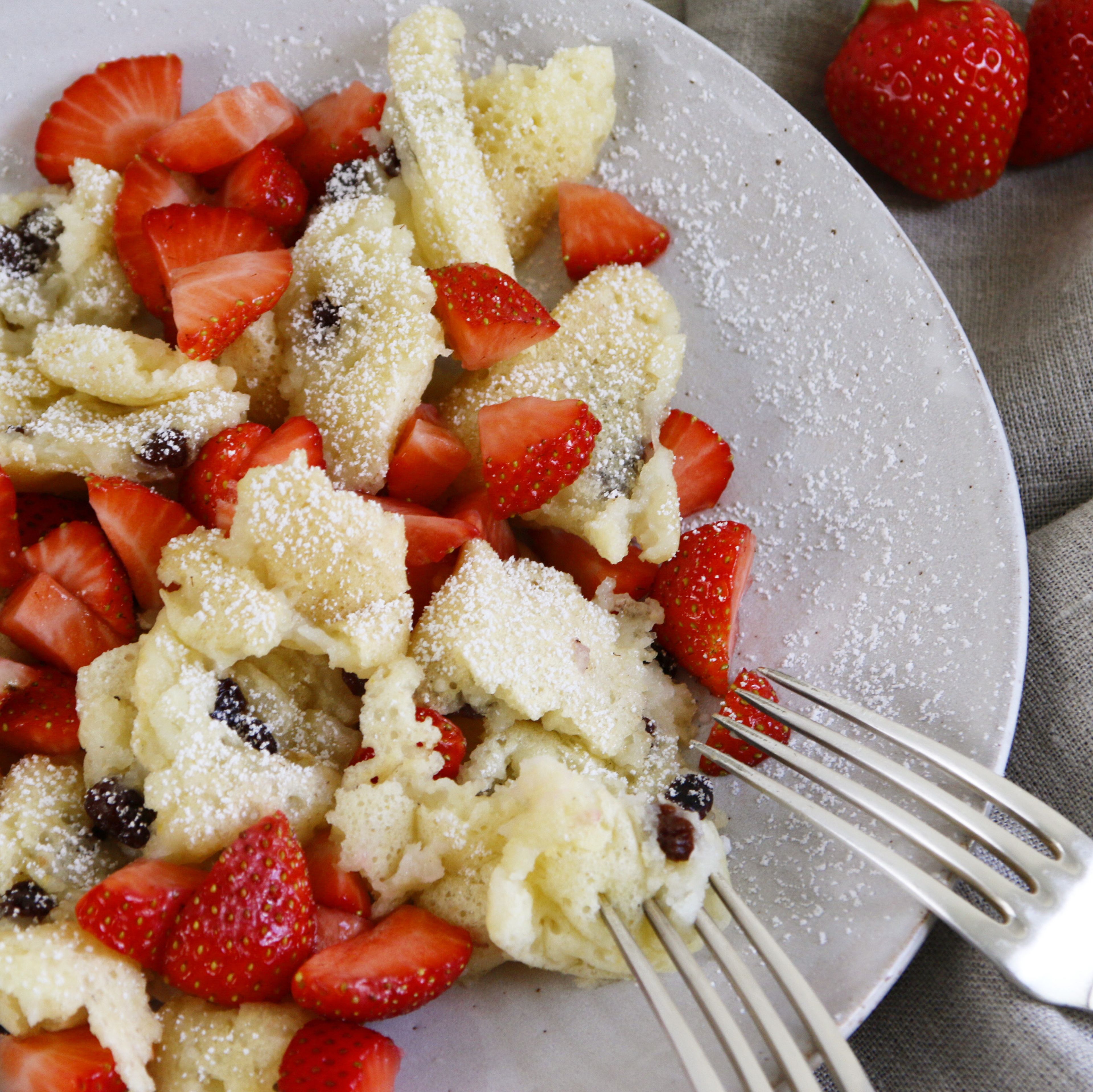 Auf Tel­lern ver­tei­len, Erd­bee­ren ver­tei­len und mit Puder­zu­cker bestreuen. Gut pas­sen auch gerös­tete Kokos­ras­peln.