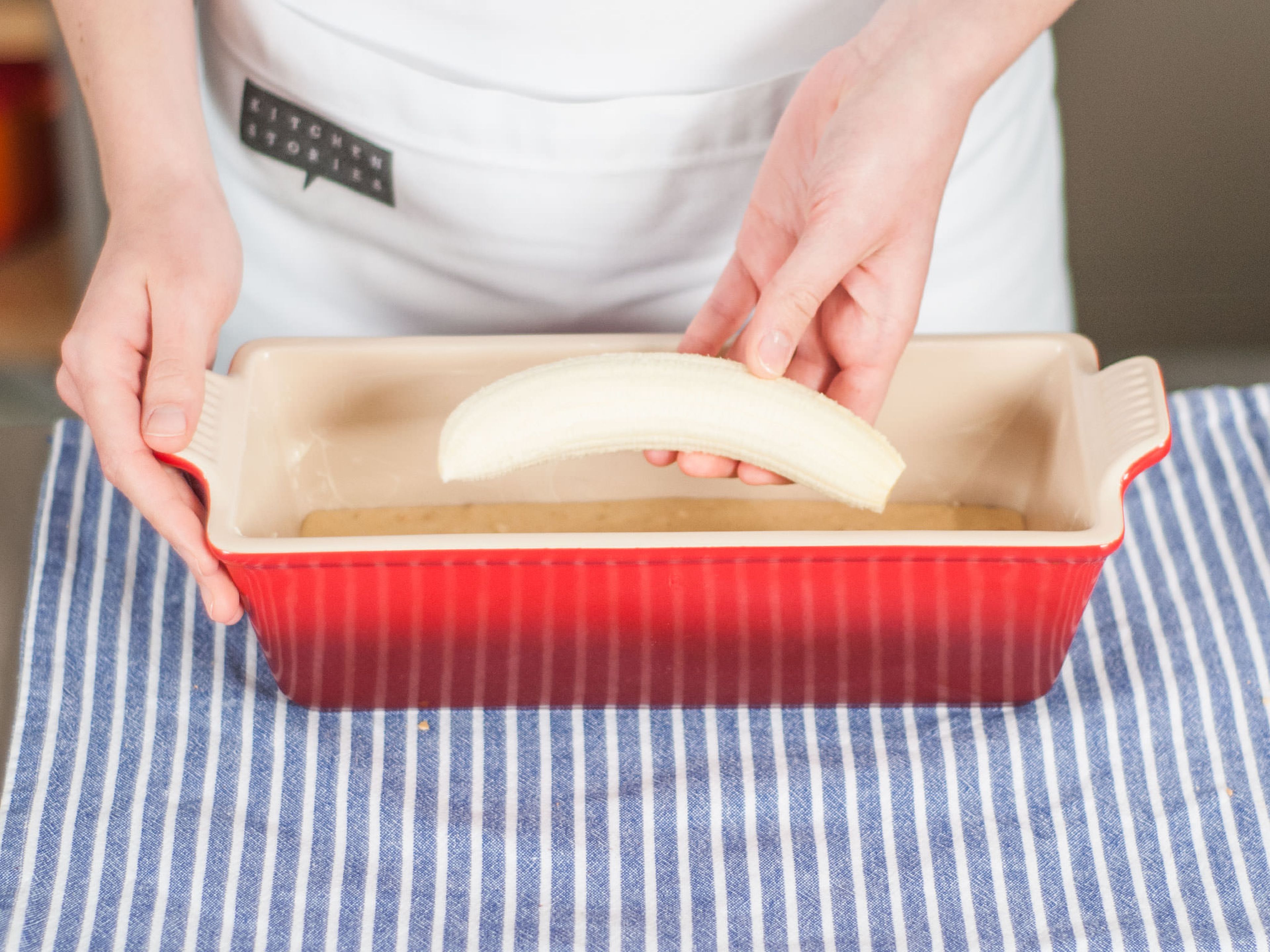 If needed, grease baking dish. Pour in half of batter. Peel remaining banana and place it on top of the batter. Cover with remaining batter. Transfer to oven and bake in preheated oven at 180°C / 350°F until an inserted toothpick comes out clean, approx. 40 – 50 min. Allow to cool, then sprinkle with confectioners’ sugar. Enjoy with whipped cream or with homemade hazelnut spread.