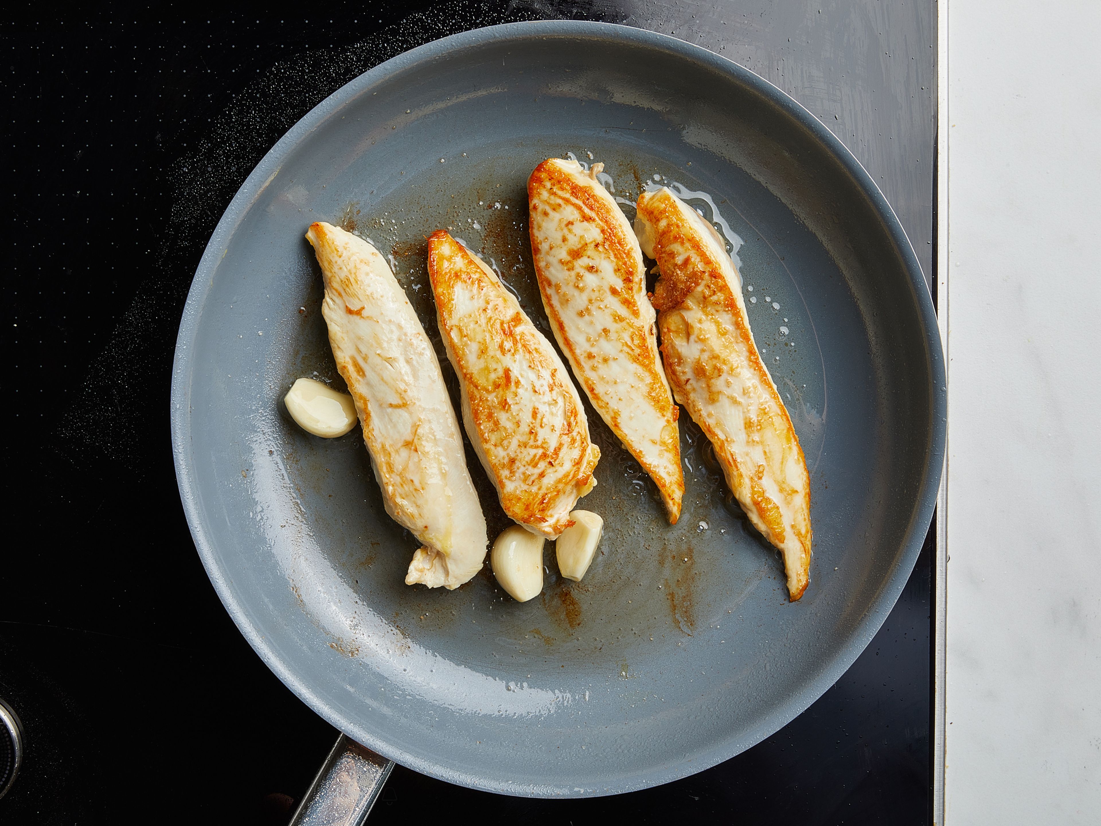 Butterfly chicken breasts, season both sides with salt. Fry in a hot pan with olive oil for approx. 5 min. on all sides, or until the chicken is cooked through. Add garlic cloves and fry briefly. Remove chicken from pan and wrap in aluminum foil. Remove garlic clove, and set aside.