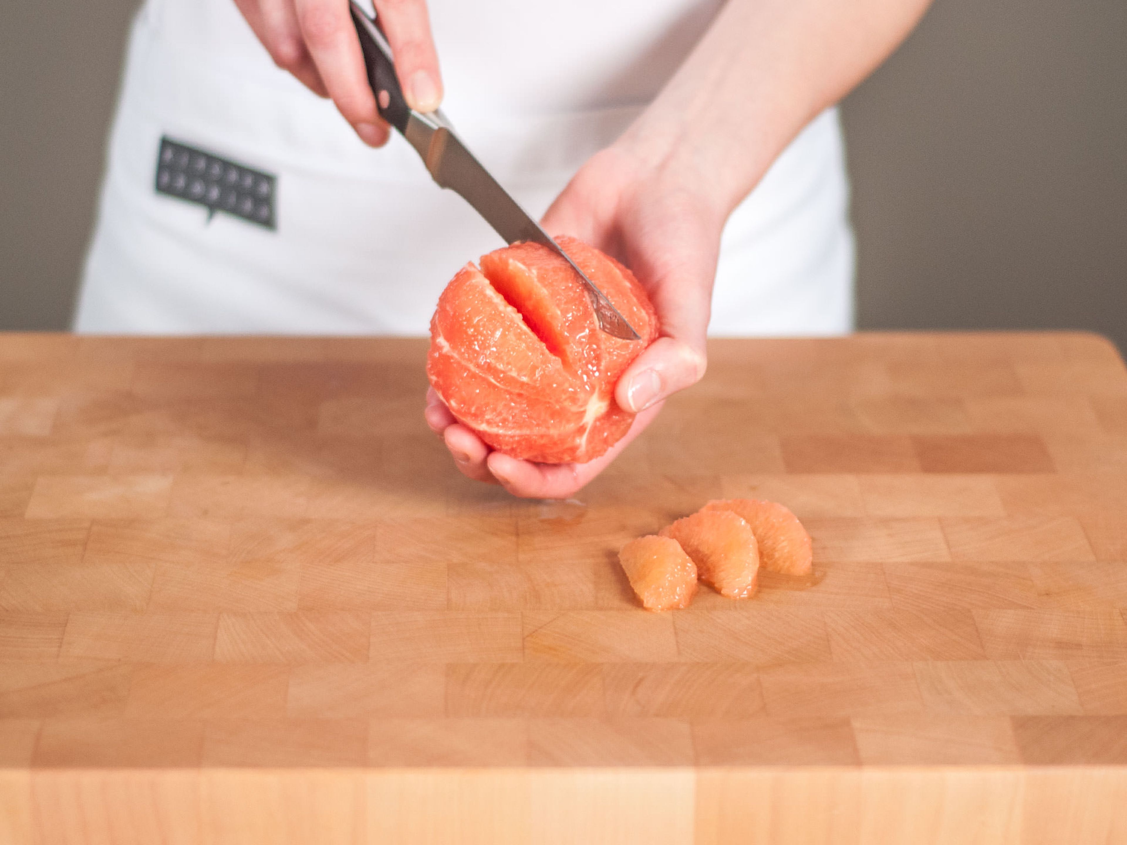 Grapefruits mit einem scharfen Messer schälen und filetieren.