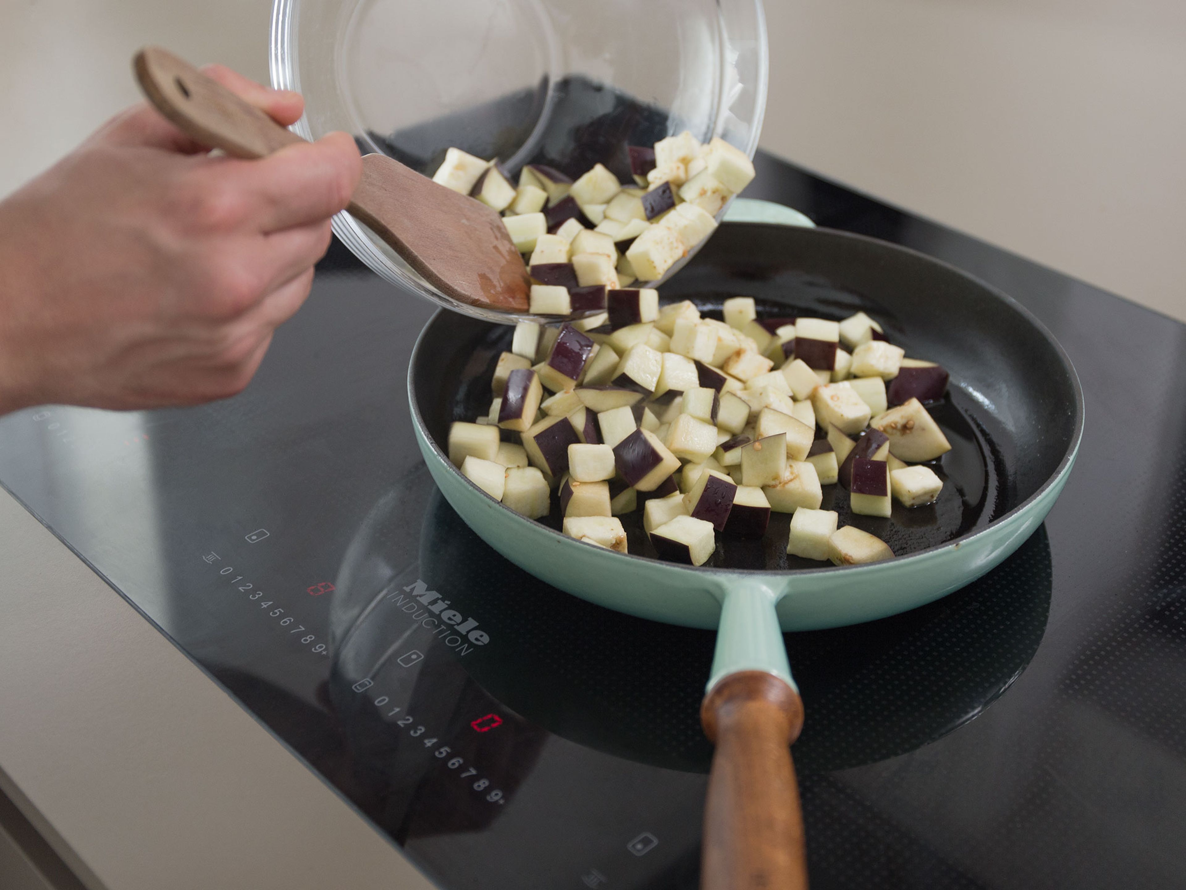 Rinse eggplant and pat dry to get rid of any excess water. Heat up the remaining olive oil in a large pan and fry the eggplant for approx. 3 - 4 min. over high heat.