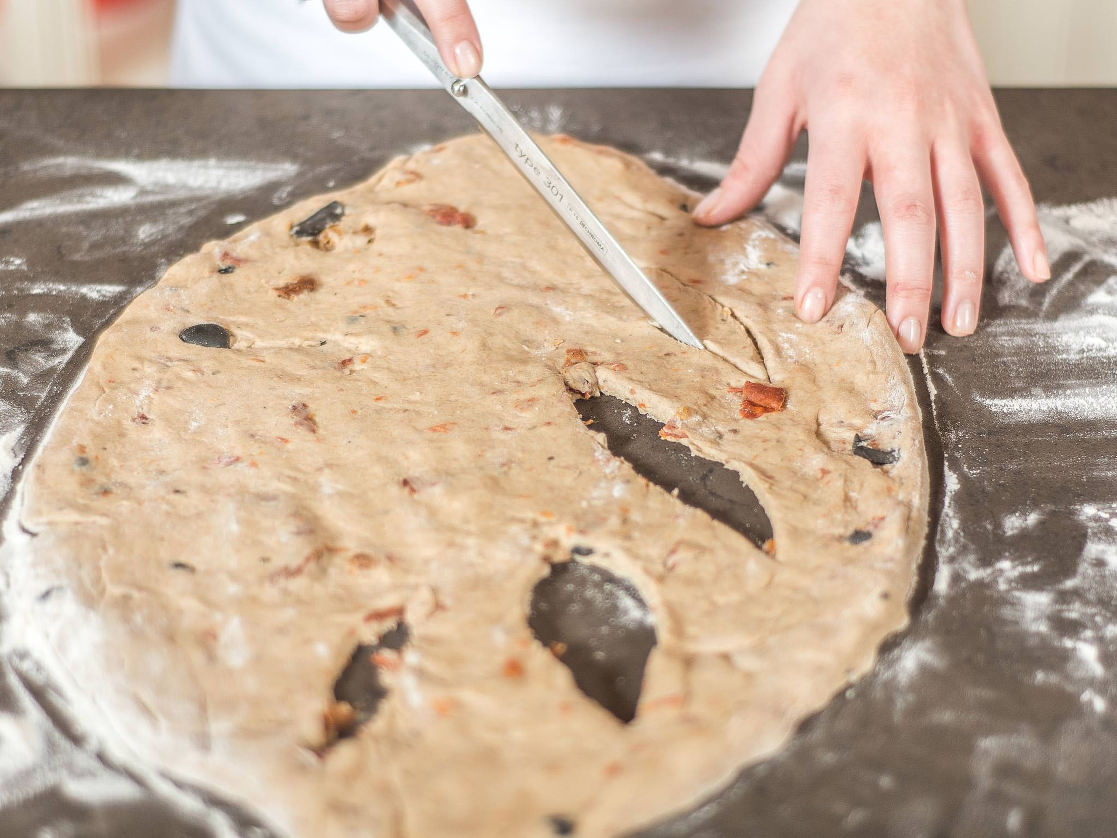 Using a sharp knife, cut out individual sections of the dough. Transfer the fougasse onto a baking rack, cover and leave to rise in a warm place for approx. 20 min.