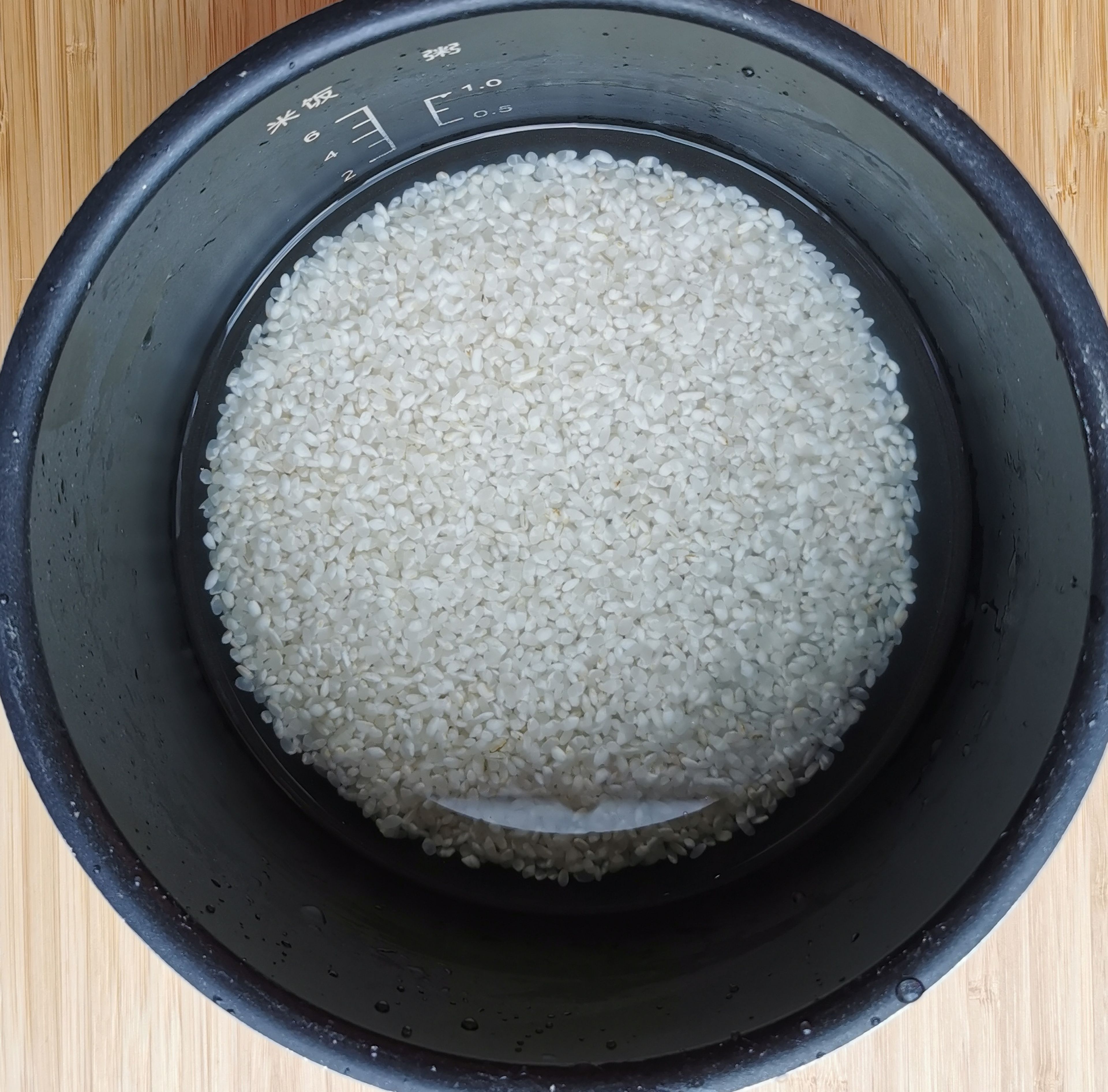 Den Reis waschen und in einen Reiskocher geben, Salami und Kartoffel hinzufügen, je nach Reissorte richtige Menge Wasser dazu und den Reiskocher einschalten.
