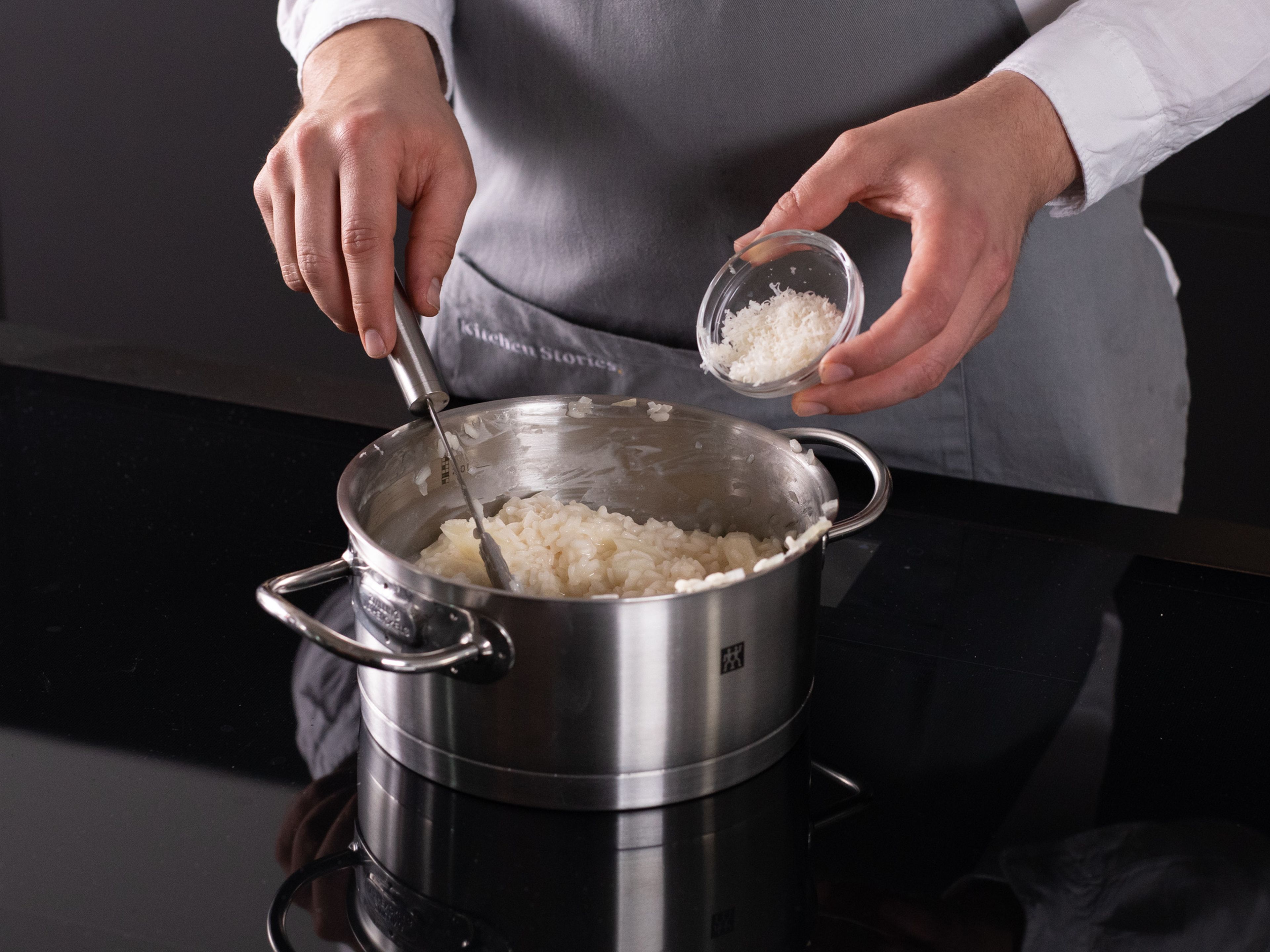 Erwärmtes Kochwasser kellenweise dazugeben und gleichmäßig einrühren, bis der Reis die Flüssigkeit absorbiert hat. Erst dann die nächste Kelle dazugeben. Diesen Schritt solange wiederholen, bis das Risotto cremig und al dente ist. Restlichen Zitronensaft und Parmesankäse unterrühren. Taleggiokäse hinzufügen und für weitere 2 Min. kochen, oder bis der Käse geschmolzen ist. Risotto mit knusprigem Brot-Topping und Spargelköpfen servieren. Guten Appetit!