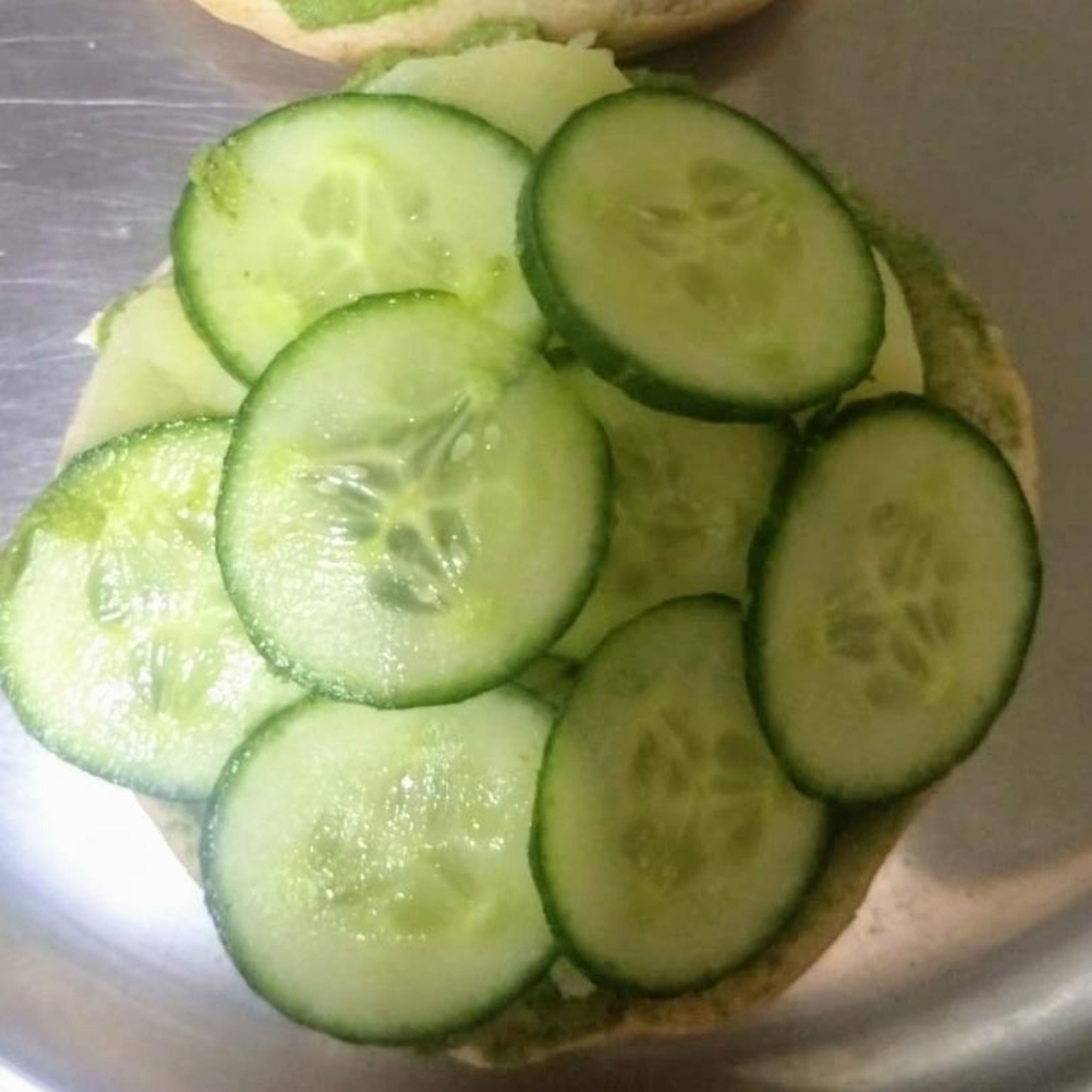 put the sliced cucumber on de bun