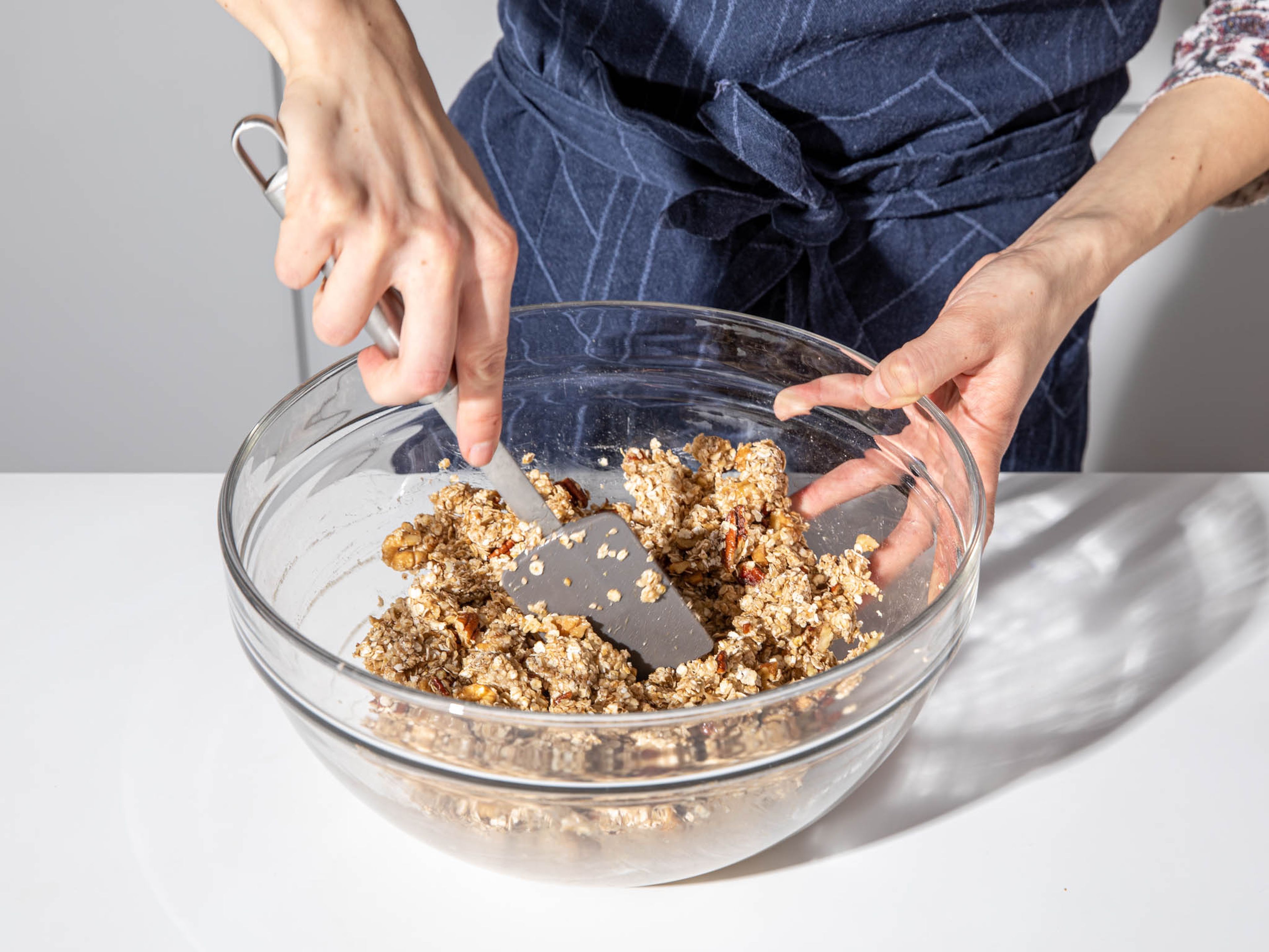 Add the maple syrup mixture to the bowl with oatmeal and nuts. Stir until everything is well combined and the oat flakes and nuts are evenly coated.