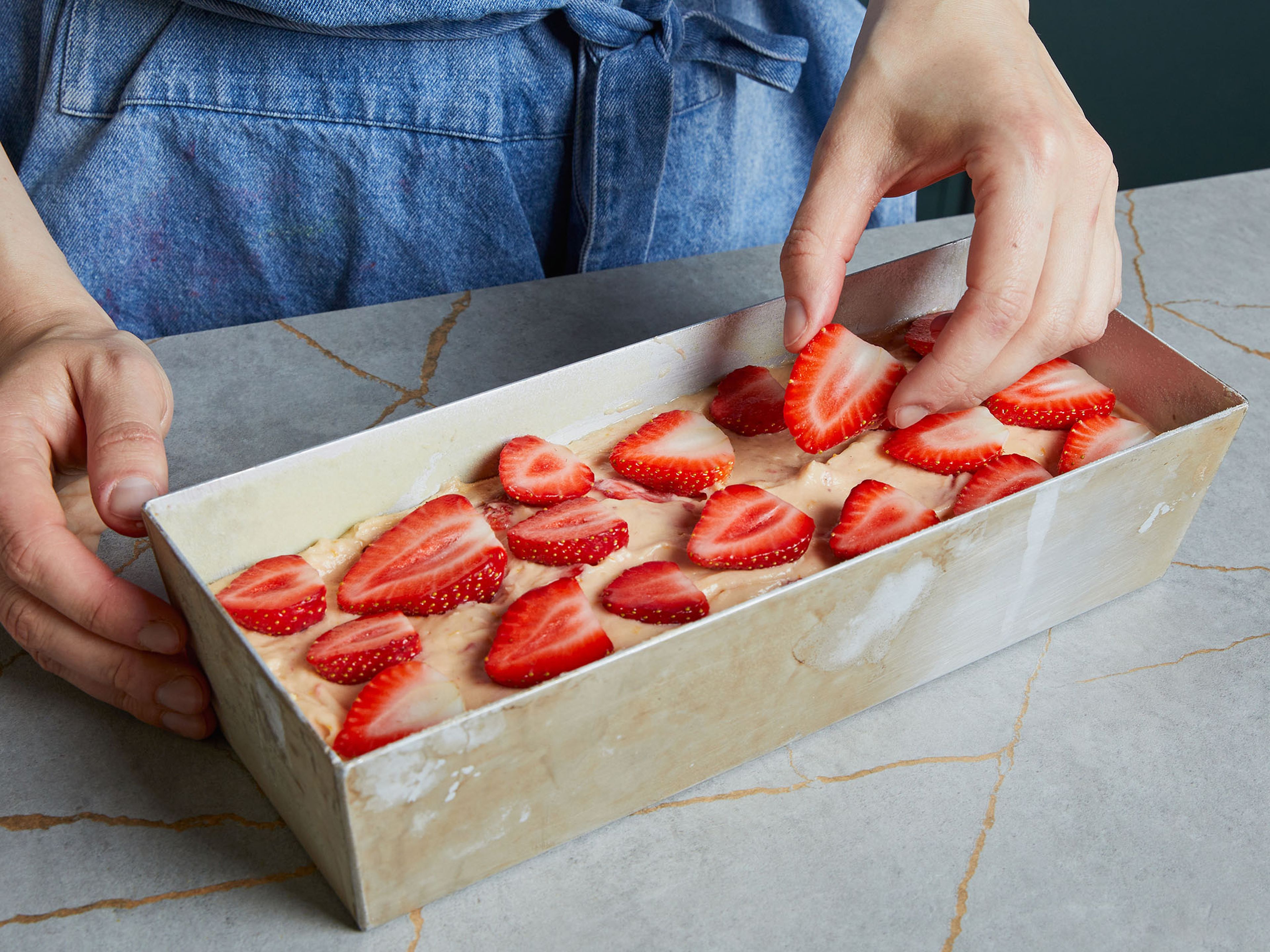Pour the batter into the prepared loaf pan and spread the remaining strawberries on the cake. Sprinkle a little more cane sugar on top, transfer to the oven and bake for approx. 65–75 min. or until a wooden skewer comes out clean when poking through. Let it cool off before removing from the loaf pan and before serving. Serve with some whipped cream or more yogurt if desired.