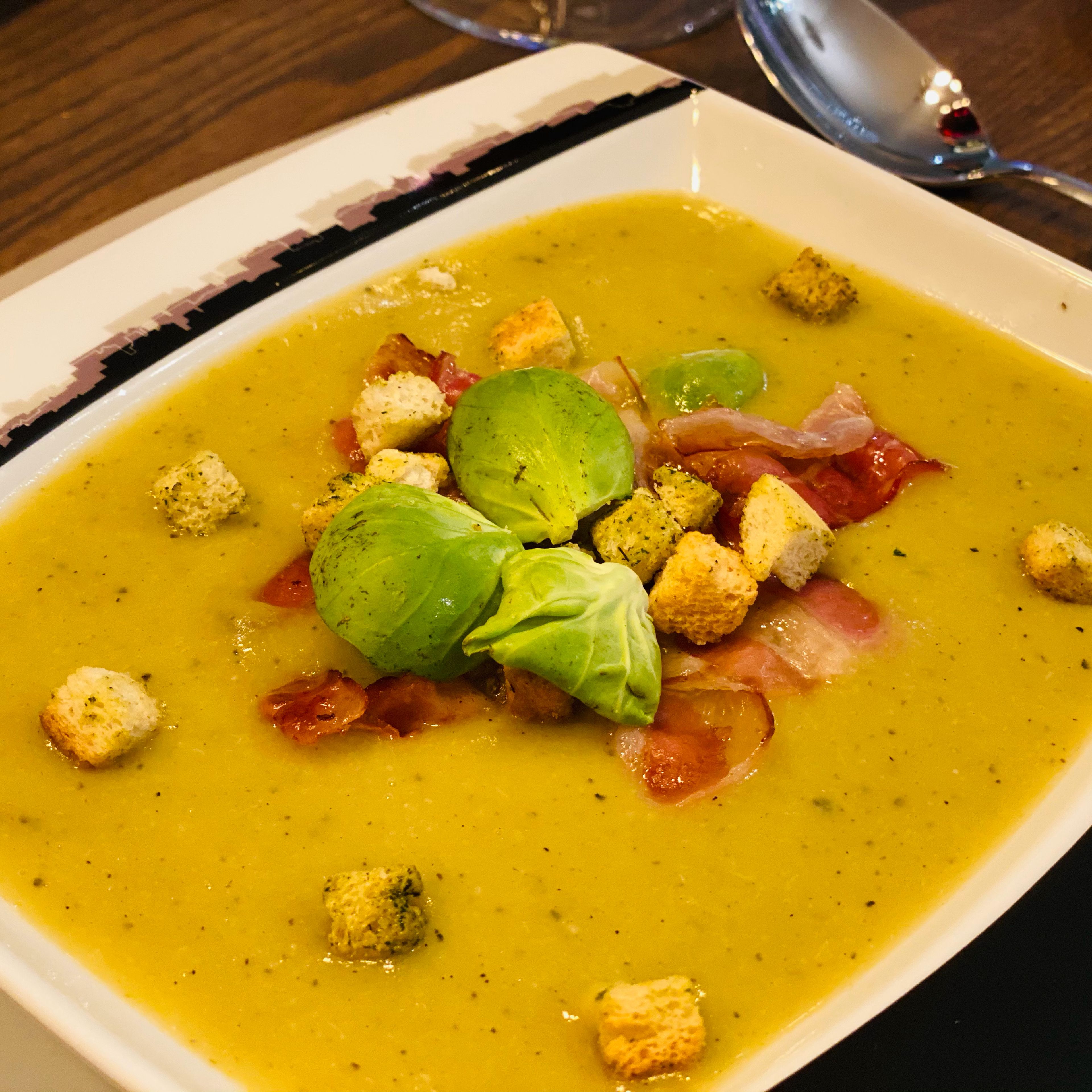 Die Suppe anrichten, mit Speck, Croûtons und je 3 Rosenkohlblättern garnieren.