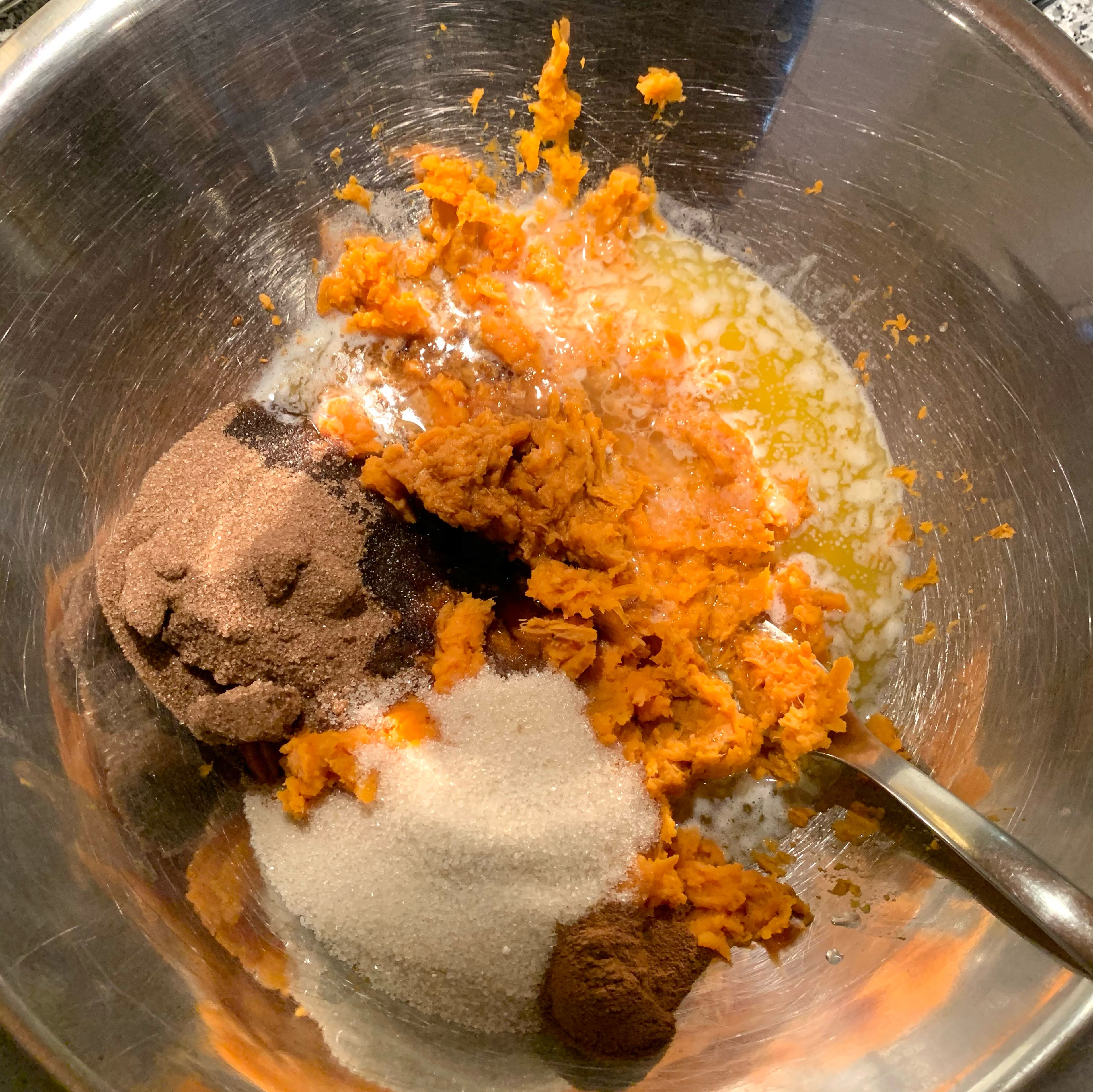 Add 1 bar of melted butter, white sugar, brown sugar, vanilla, ground cinnamon and lemon to the smashed sweet potatoes. Mix everything with a fork.