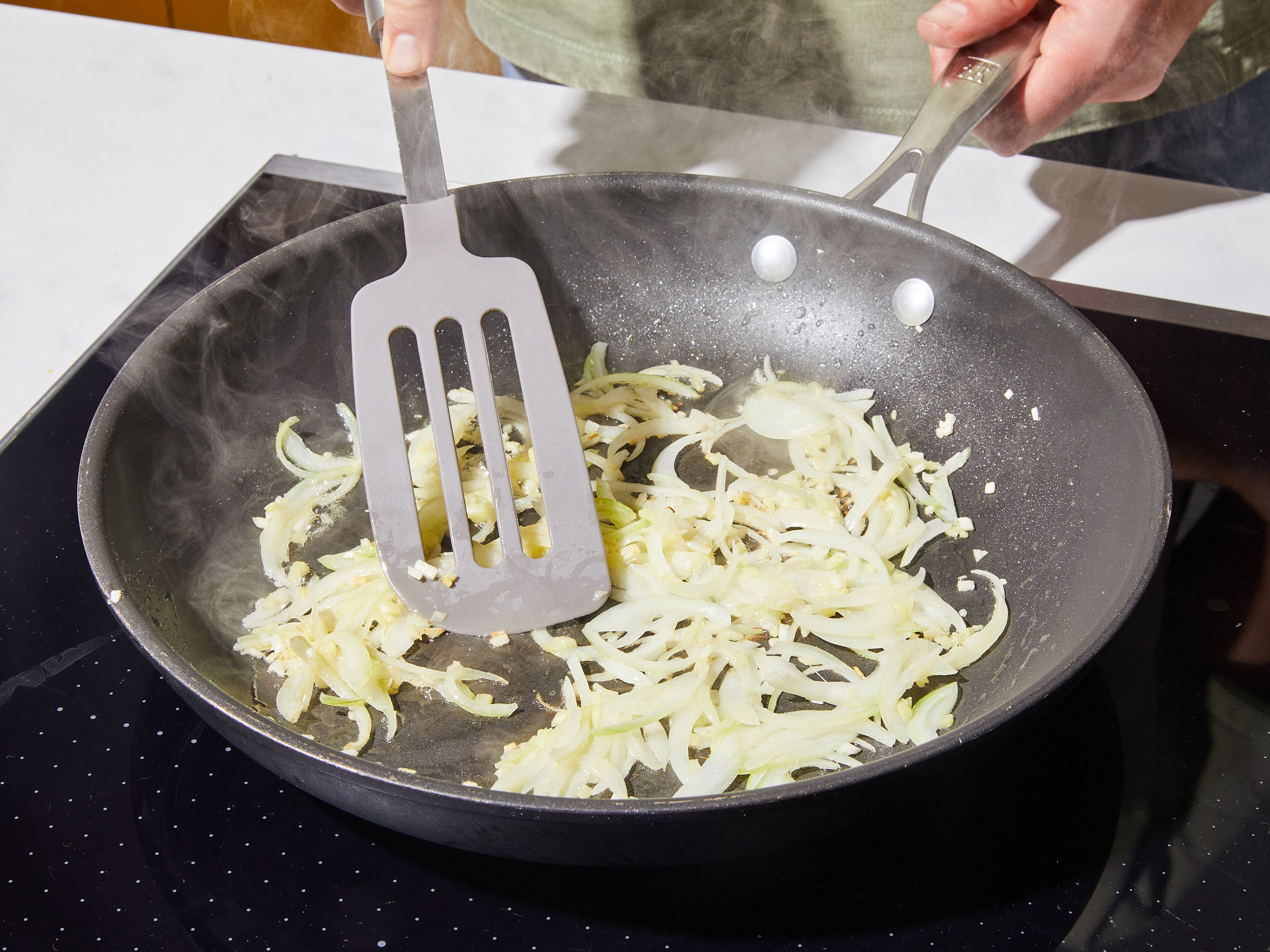 Butter in eine große, beschichtete Pfanne geben und bei mittlerer Hitze schmelzen. Sobald sie geschmolzen ist, Zwiebeln, Knoblauch und Ingwer hinzugeben und ca. 5 Min. anbraten, bis sie weich sind.