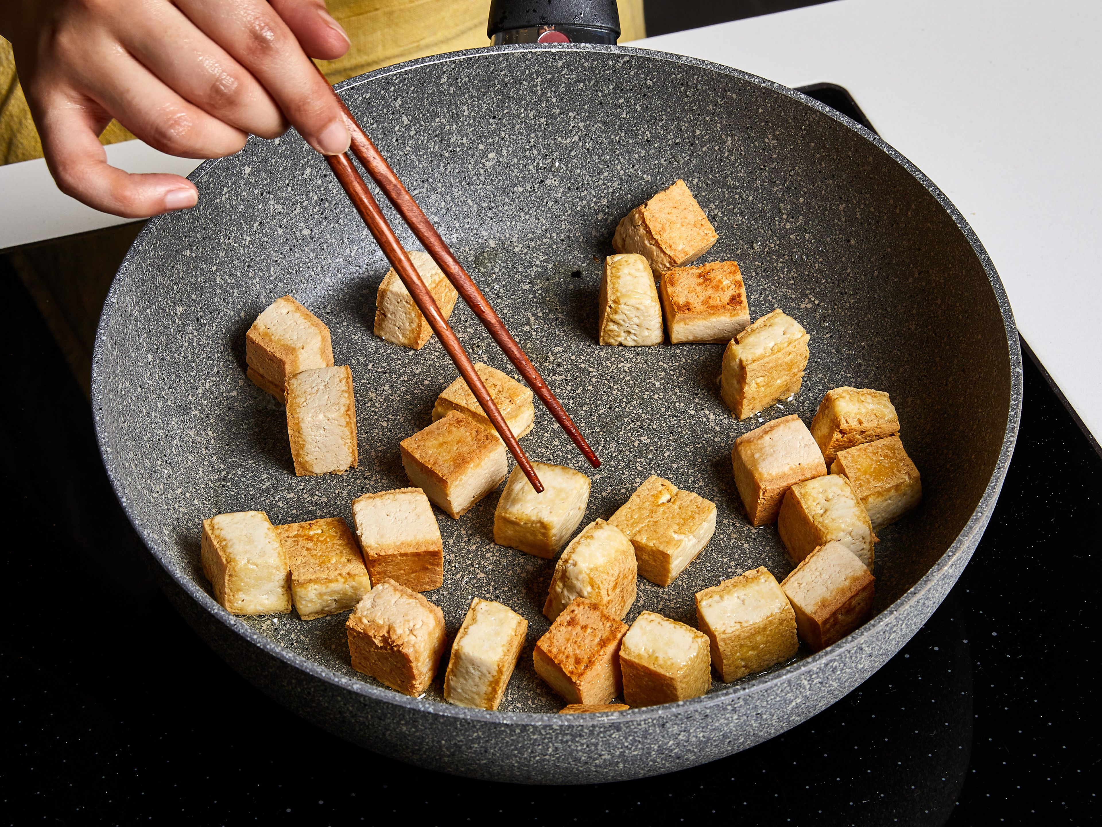 In a deep, non-stick frying pan, heat vegetable oil over medium heat, add tofu cubes, fry until all sides are golden, for about 2-3 min. per side. Remove from the pan and set aside. Add green beans, fry for about 3 min.