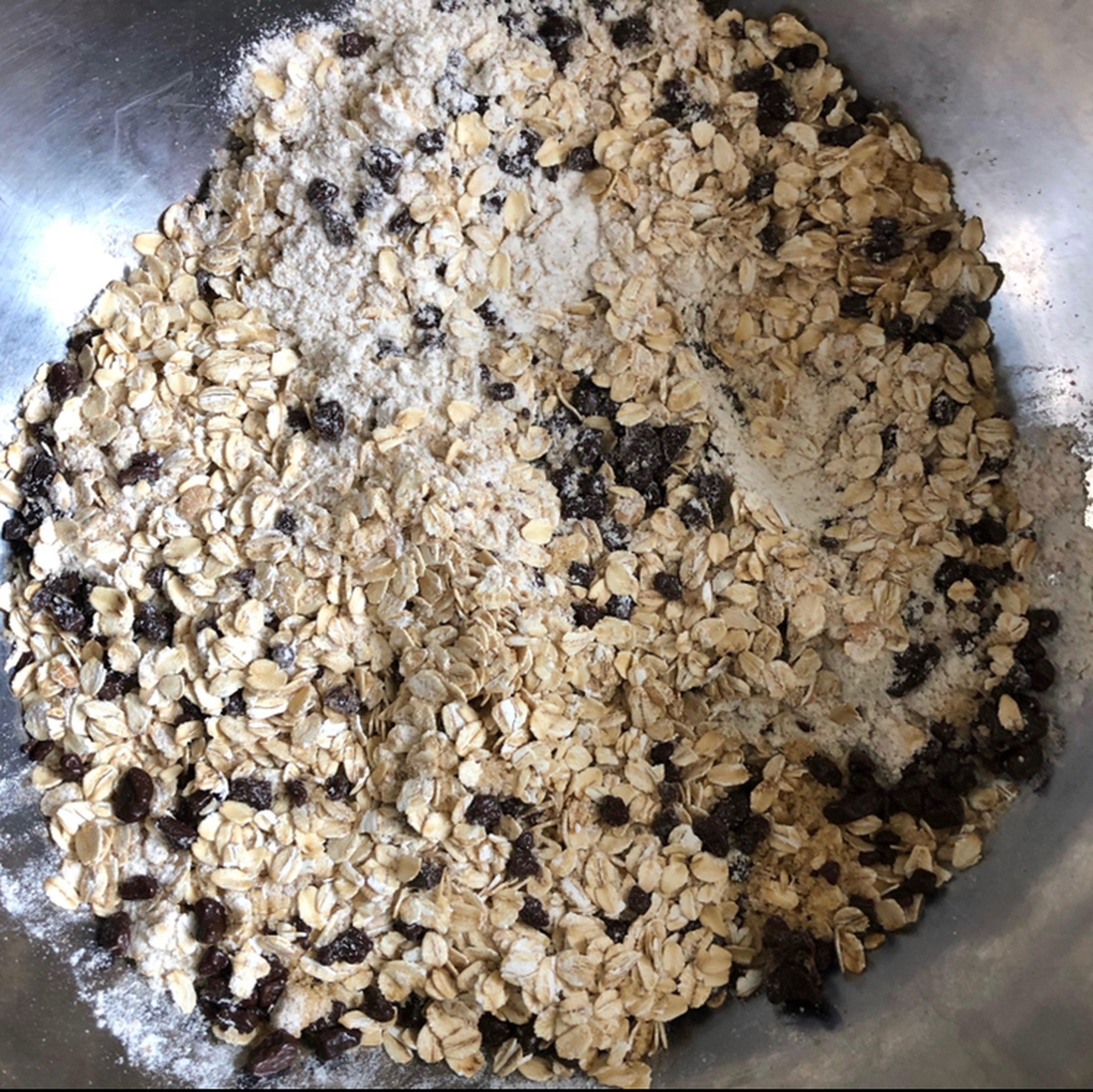 Putt rolled oats, whole-wheat flour, brown sugar and semi-sweet chocolate chips into a large bowl and mix the mixture with a spatula or a tablespoon.