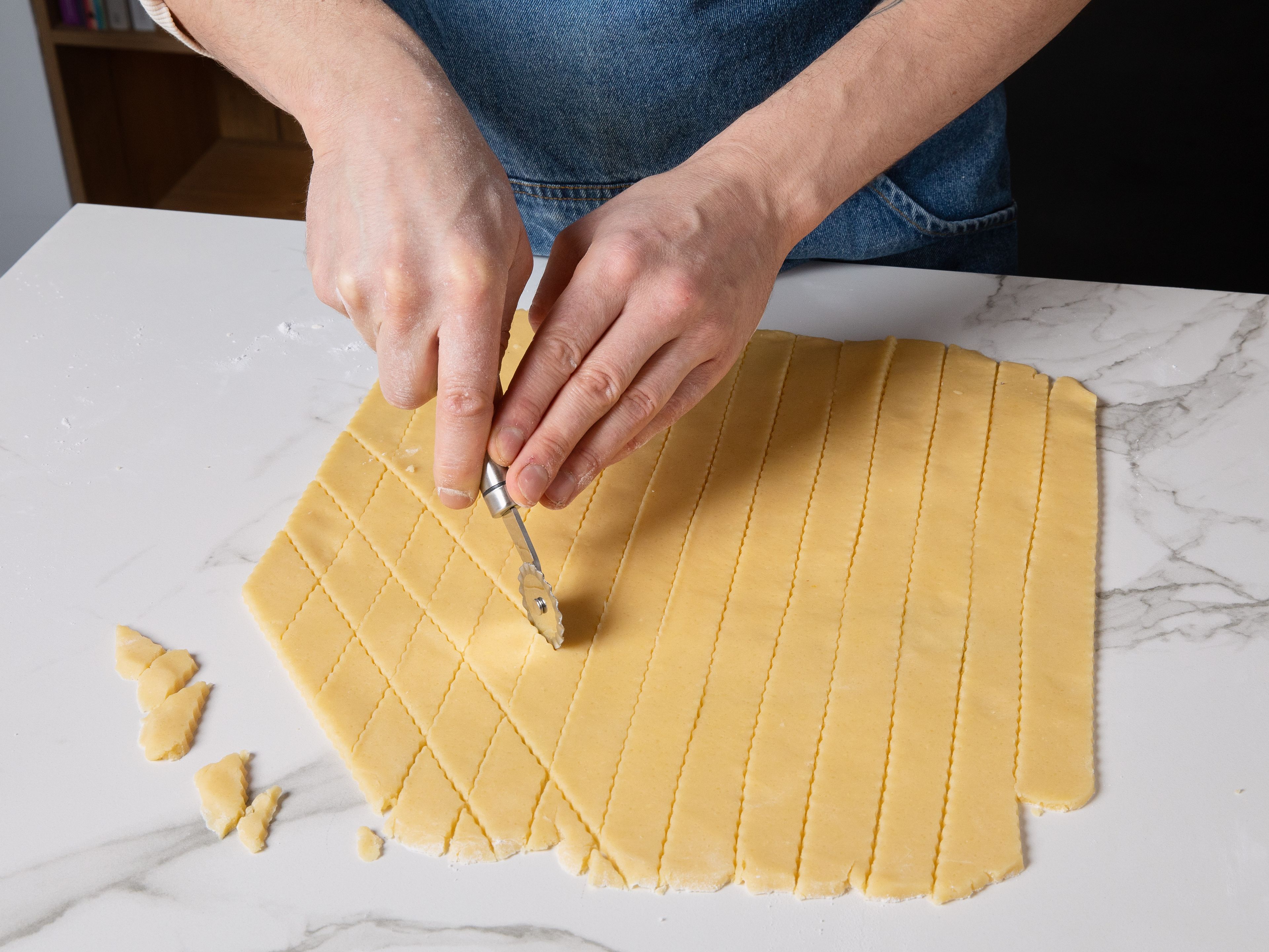 Dust work surface with flour, roll out the dough portion by portion approx. 2 mm/0.08 in. thin, and cut into approx. 3x3 cm/1.2 in. diamonds with a serrated pastry cutter. Then, arrange them on a baking sheet lined with parchment paper. For the glaze, slice vanilla bean lengthwise and scrape out the seeds. In a bowl, beat egg white, a pinch of salt, and vanilla seeds until stiff, gradually sprinkling in powdered sugar.