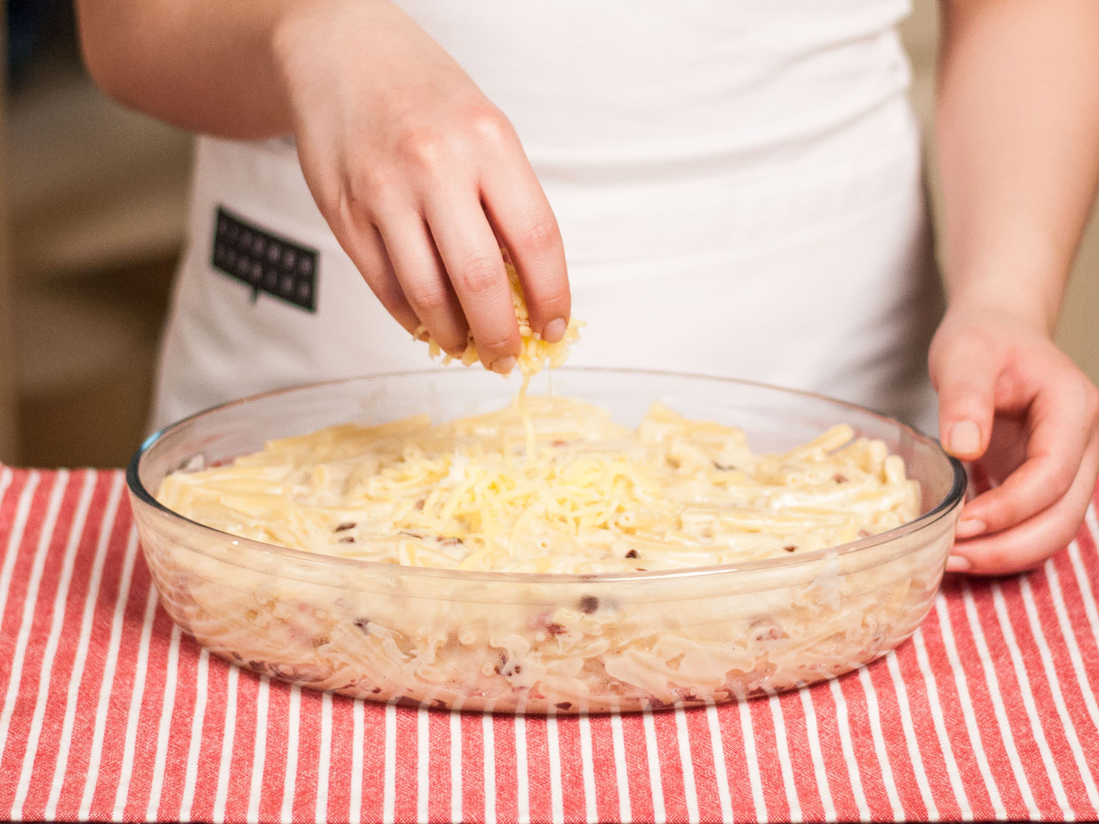 Add precooked pasta to the cheese sauce and mix briefly. Pour everything into a greased baking dish, sprinkle with the remaining cheese and bake in preheated oven at 180°C/ 355°F. for approx. 30 – 35 min. until golden.
