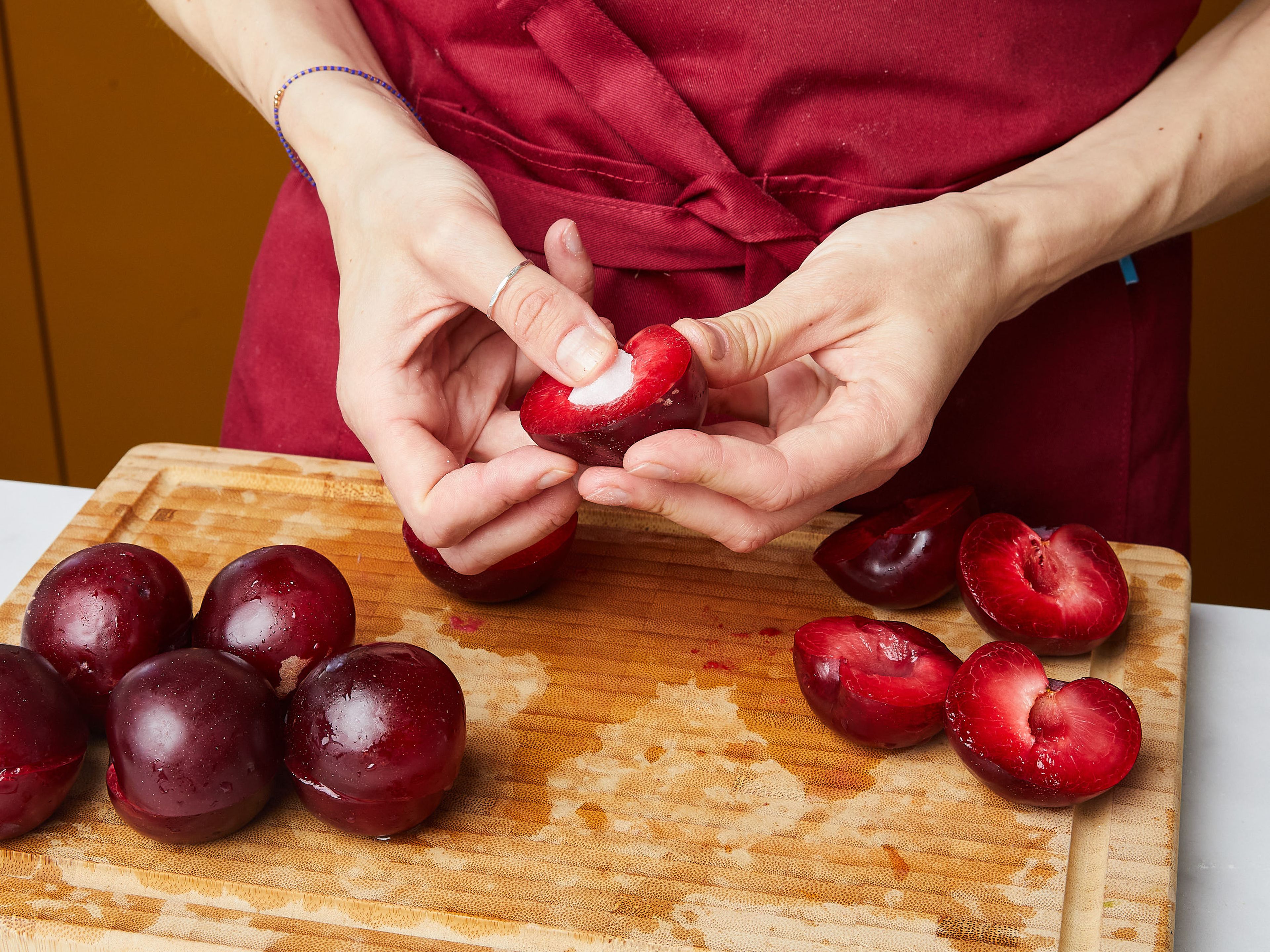 In the meantime, cut the plums in half, and remove the pit. Then press a piece of sugar cube into each plum and close it again.