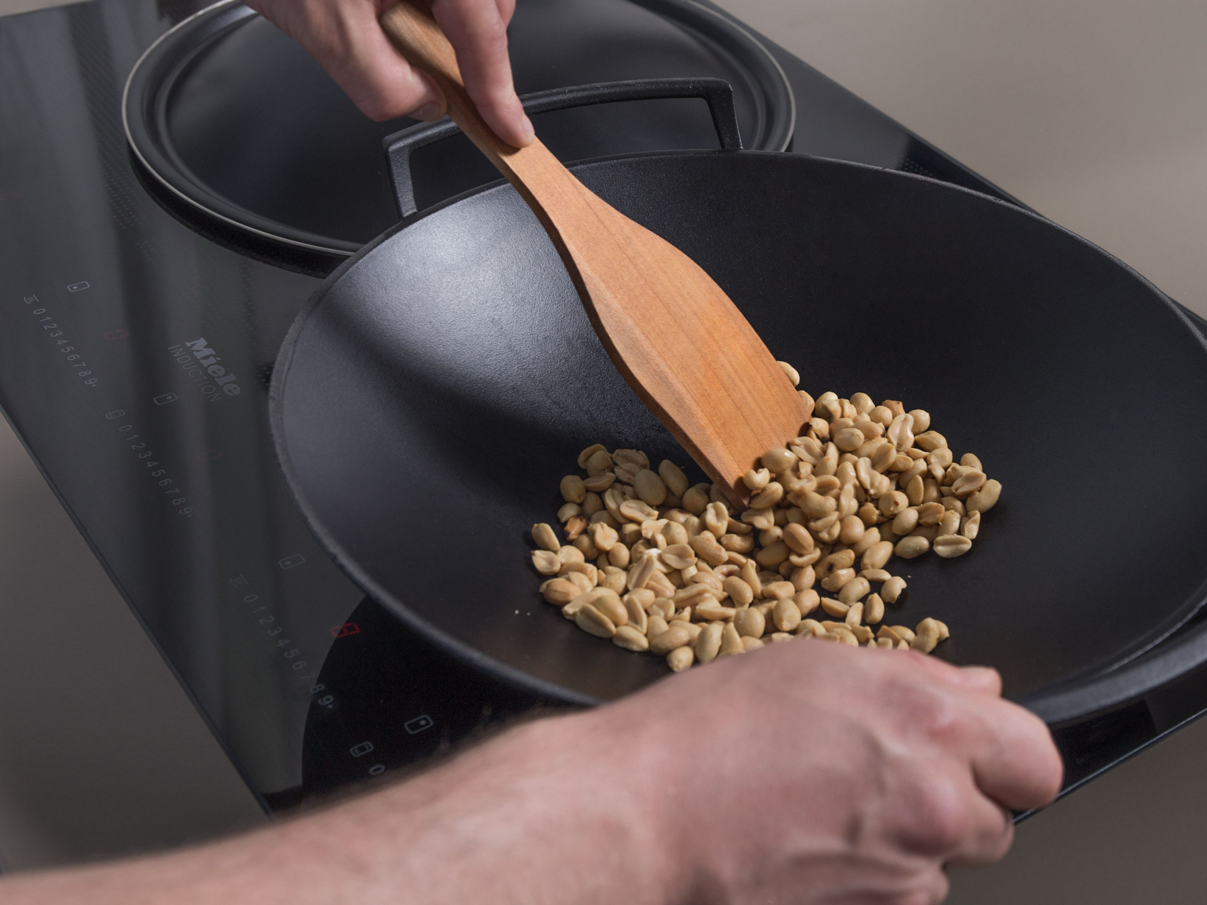Erdnüsse im Wok auf mittlerer bis hoher Hitze ca. 2 - 3 Min. rösten, oder bis sie goldbraun sind und duften. Aus der Pfanne nehmen und beiseitestellen.