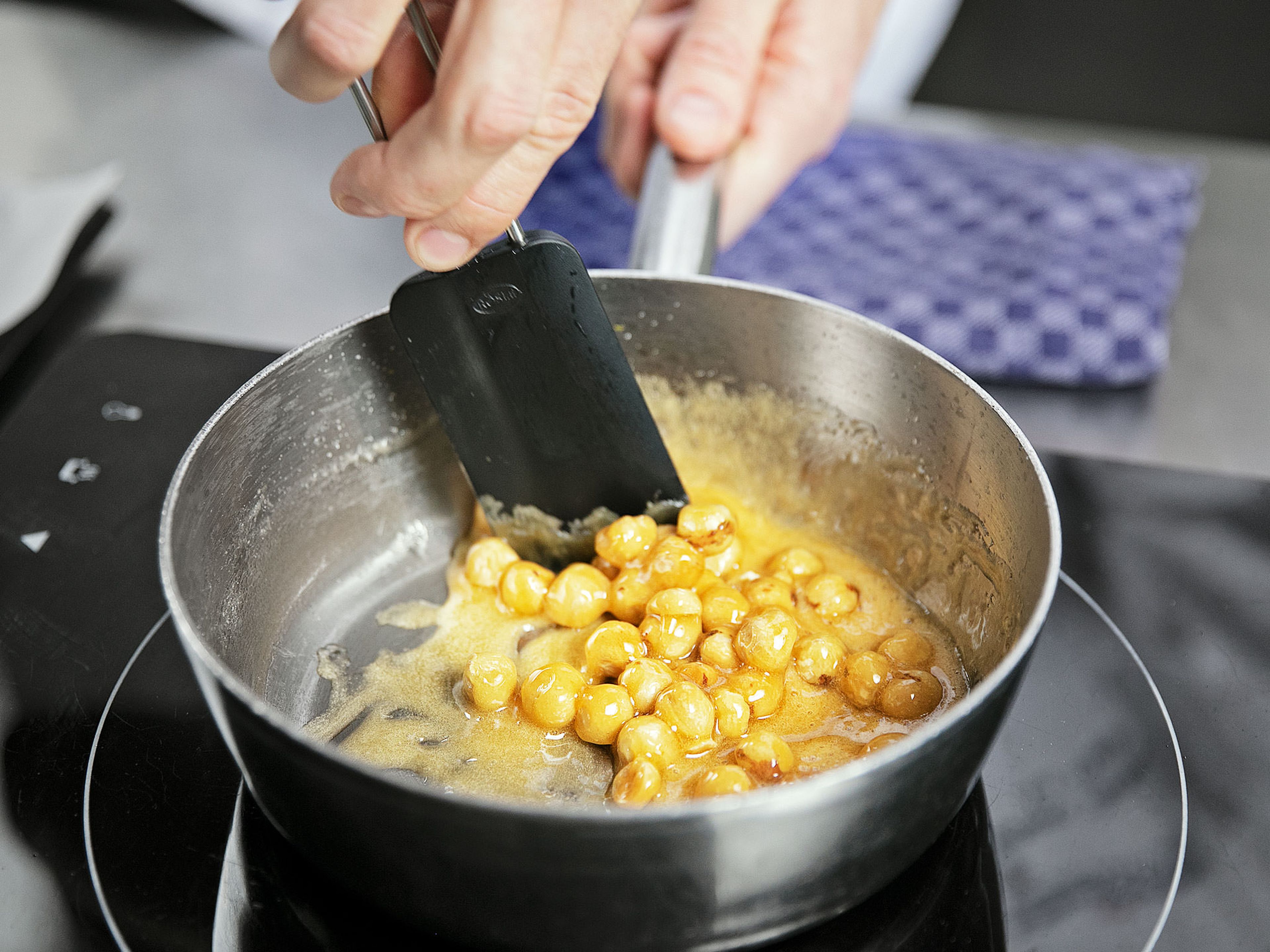 Stir in baking powder and remaining whole hazelnuts, then transfer to a baking sheet and allow to cool. For the orange filling, grate oranges and set zests aside. Crush lemongrass stalk, chop, and transfer to a small saucepan. Grind cardamom pod, coriander seeds, clove, and star anise in a mortar and transfer to the saucepan. Juice oranges, add juice to saucepan and bring to a simmer. Let reduce, then strain through a sieve and transfer back to the saucepan.