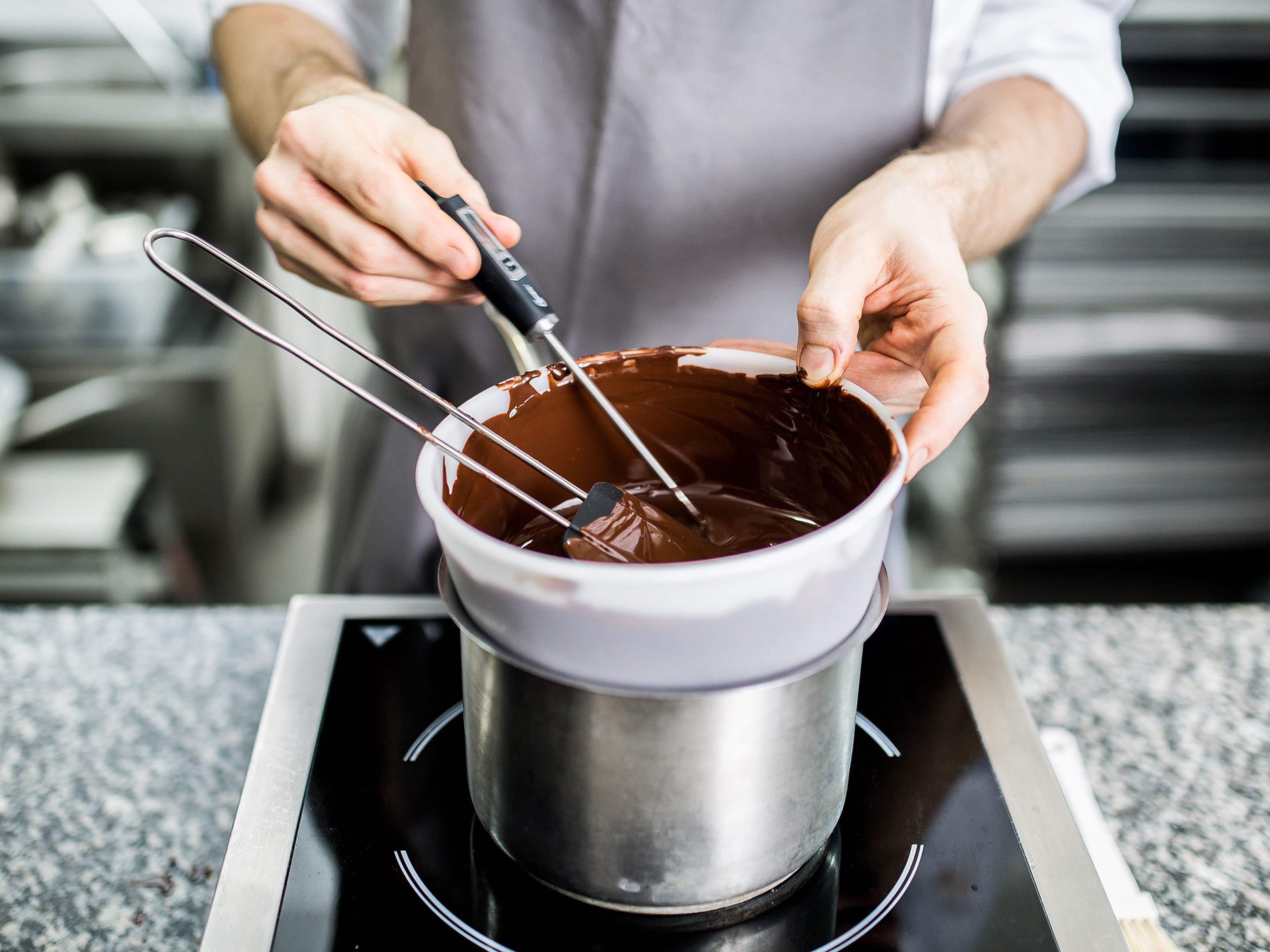 Set up a double-boiler by placing a heatproof bowl over a small pot of simmering water. Place half of the chocolate in the heatproof bowl and melt. Take off heat once it has reached 50°C/122°F. Set aside. Add rest of chocolate and gently stir.