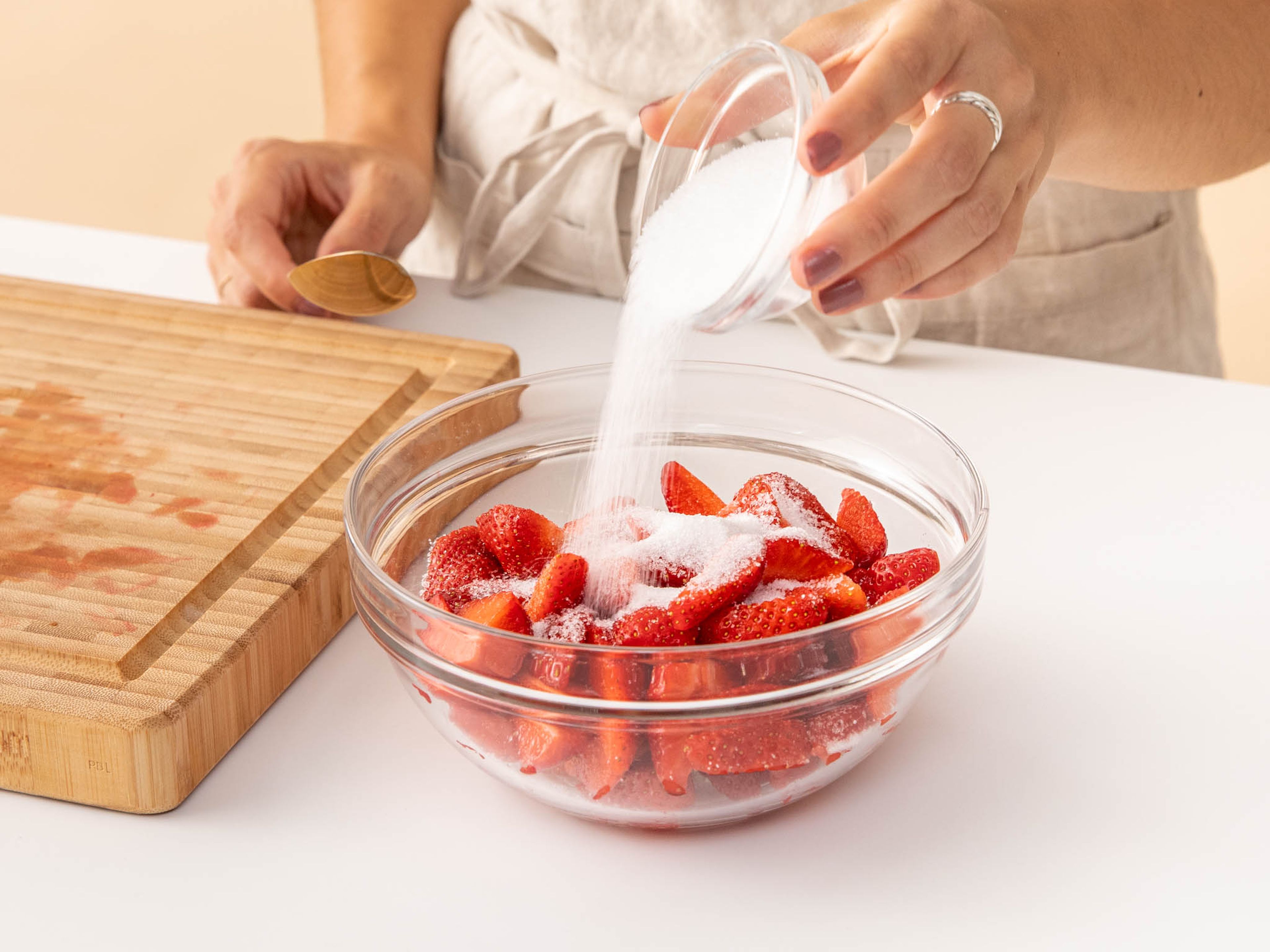Erdbeeren waschen und Strunk entfernen. Erdbeeren vierteln und mit der Hälfte des Zuckers mischen. Für ca. 10 Min. oder bis die glänzend werden und einen Teil ihres Safts abgeben, ruhen lassen.