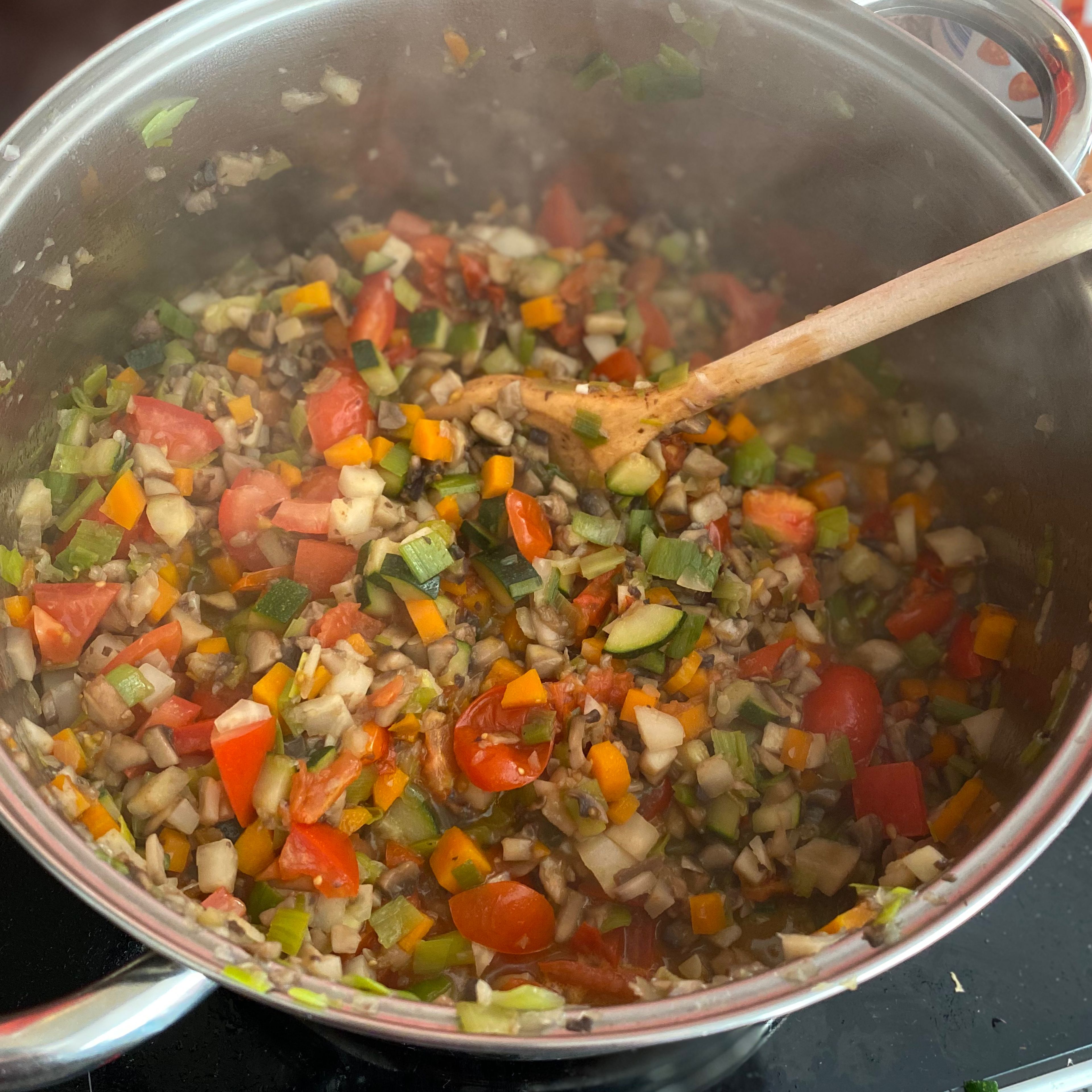 Jetzt kommen noch die frischen Tomaten hinzu. Dann die Gemüsebrühe dazugeben und noch einmal aufkochen lassen, die gehackten und passierten Tomaten hinzufügen. Nun kommen noch die Gewürze hinzu (nach Geschmack). Jetzt lassen wir die Soße bei mittlerer Hitze für ca 1 Stunde köcheln. Dabei den Deckel schräg auflegen. Zwischendurch umrühren.