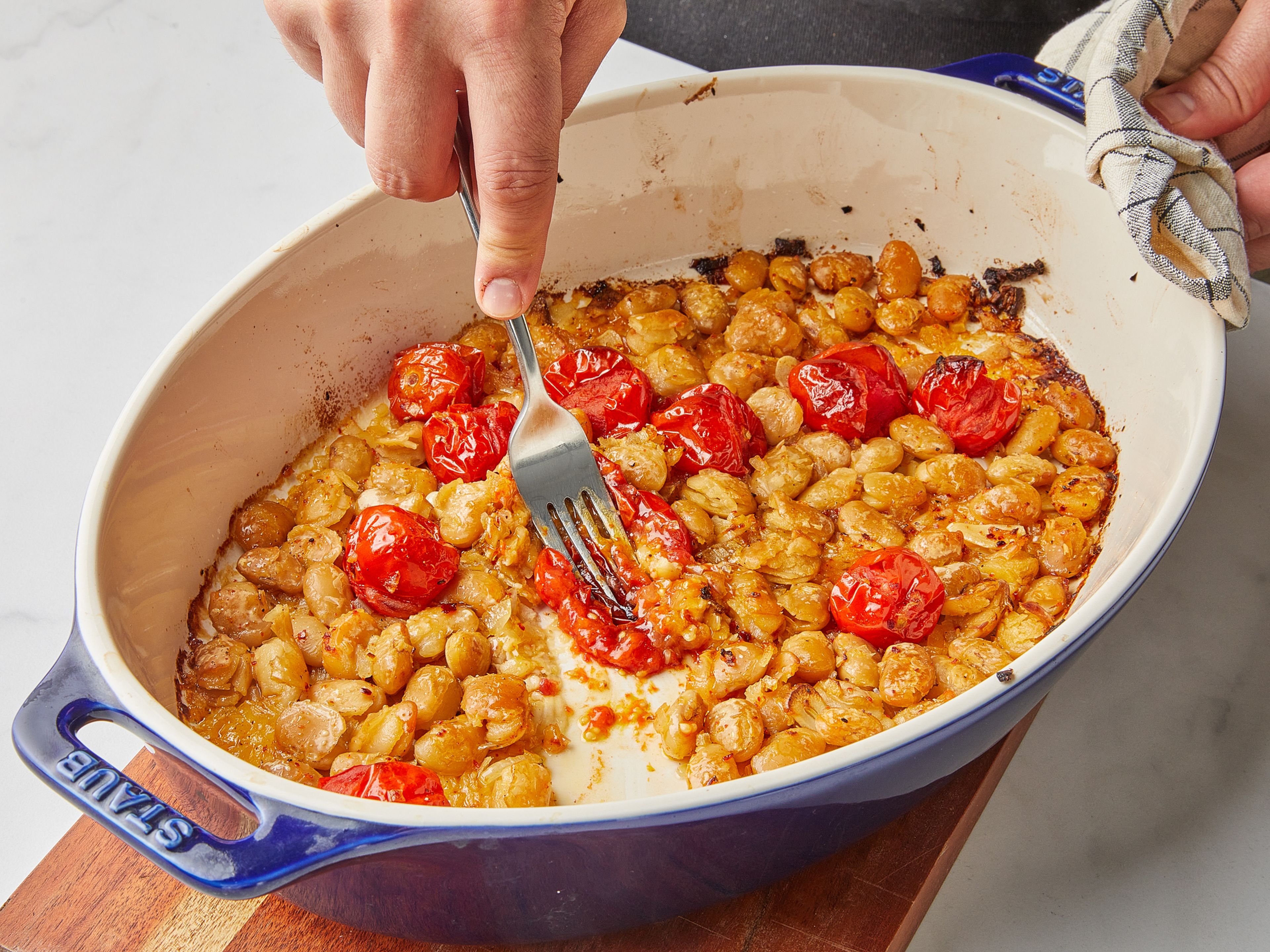 Remove the baking dish from the oven. Mash tomatoes with a fork, then mix with the beans and mash them a little as well. Let stand for approx. 10 min. so that the liquid thickens. Season to taste with apple cider vinegar, more salt and pepper if needed. Serve with toasted bread, basil and more olive oil. Enjoy!