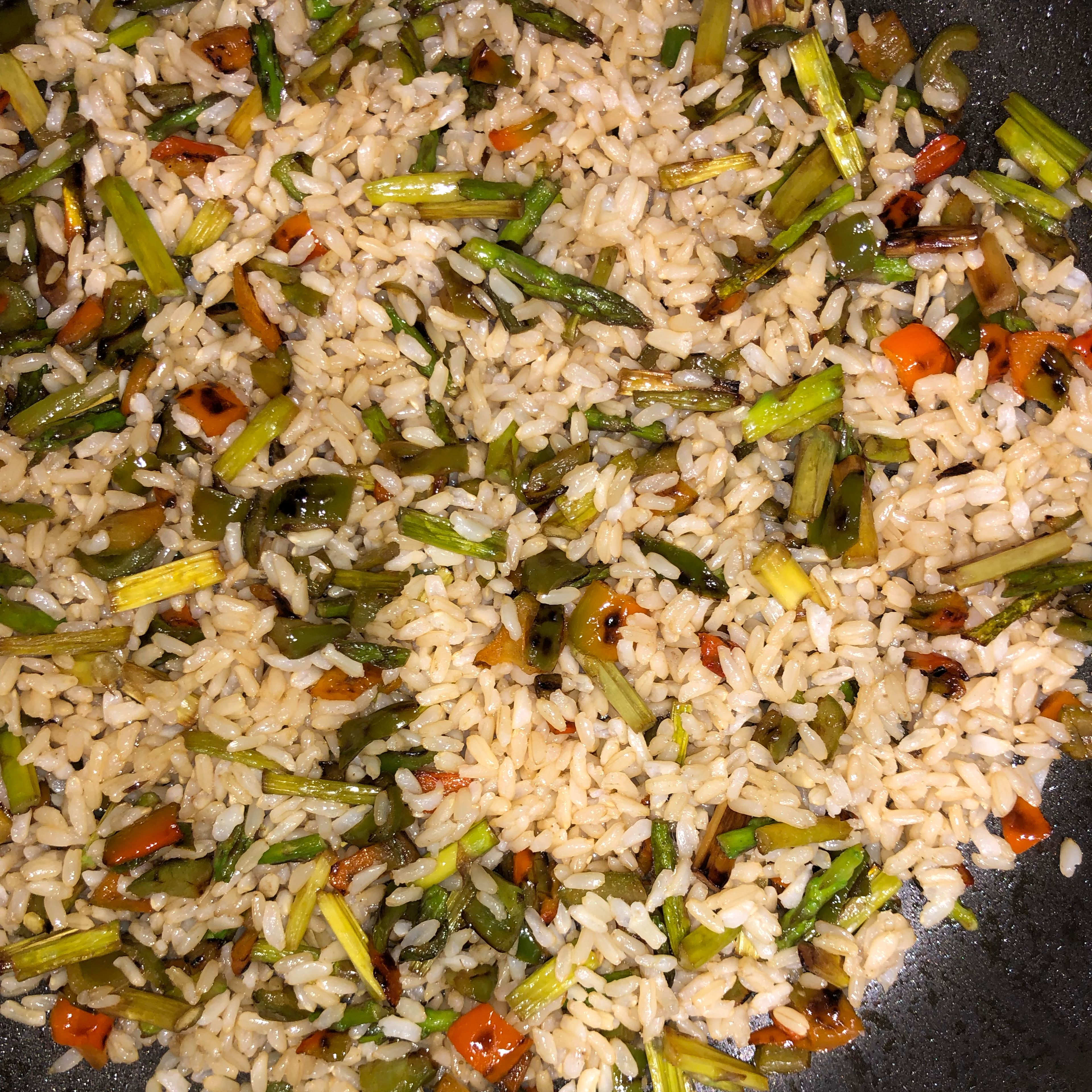 Add the preboiled brown rice to the pan with the vegetables.