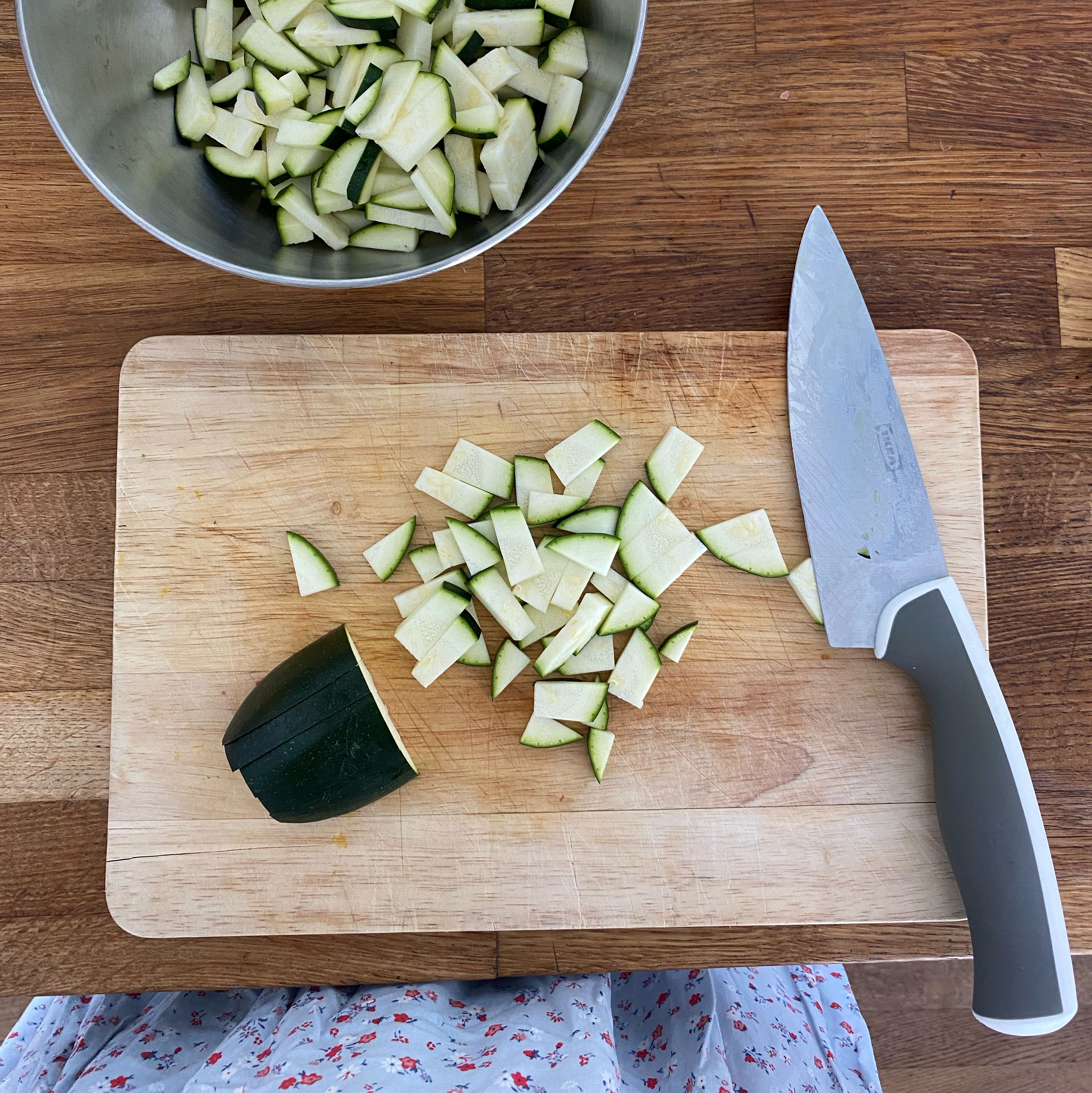 Wasser mit Wasserkocher aufkochen lassen. In der Zeit Zucchini, Schalotten und Knoblauch waschen/schälen und schnibbeln und in einer Schüssel sammeln.