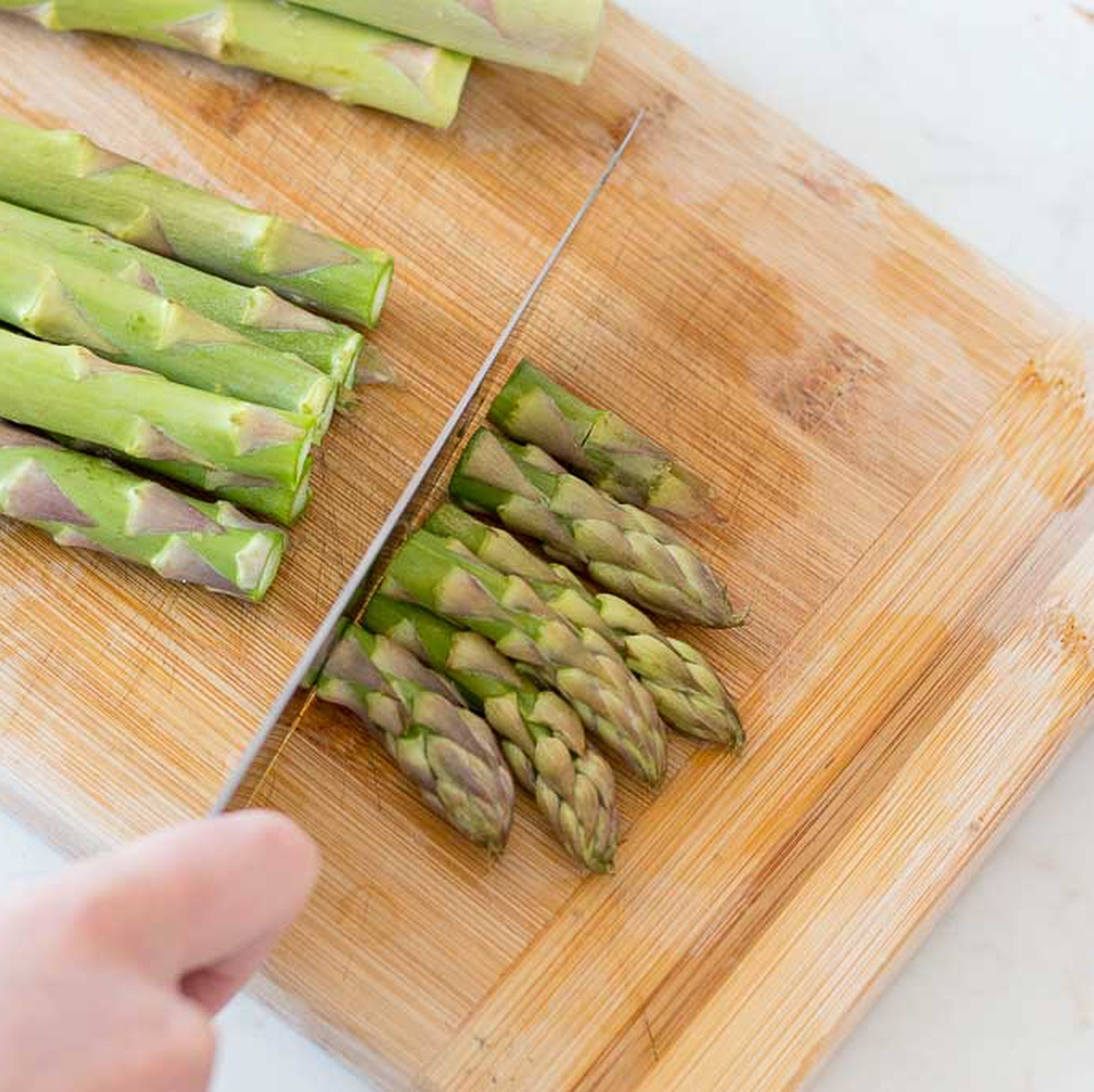 Chop the asparagus, leaving the woody roots aside. Chop the flowers first and cut them in half. Chop the reming of the stems as rings.