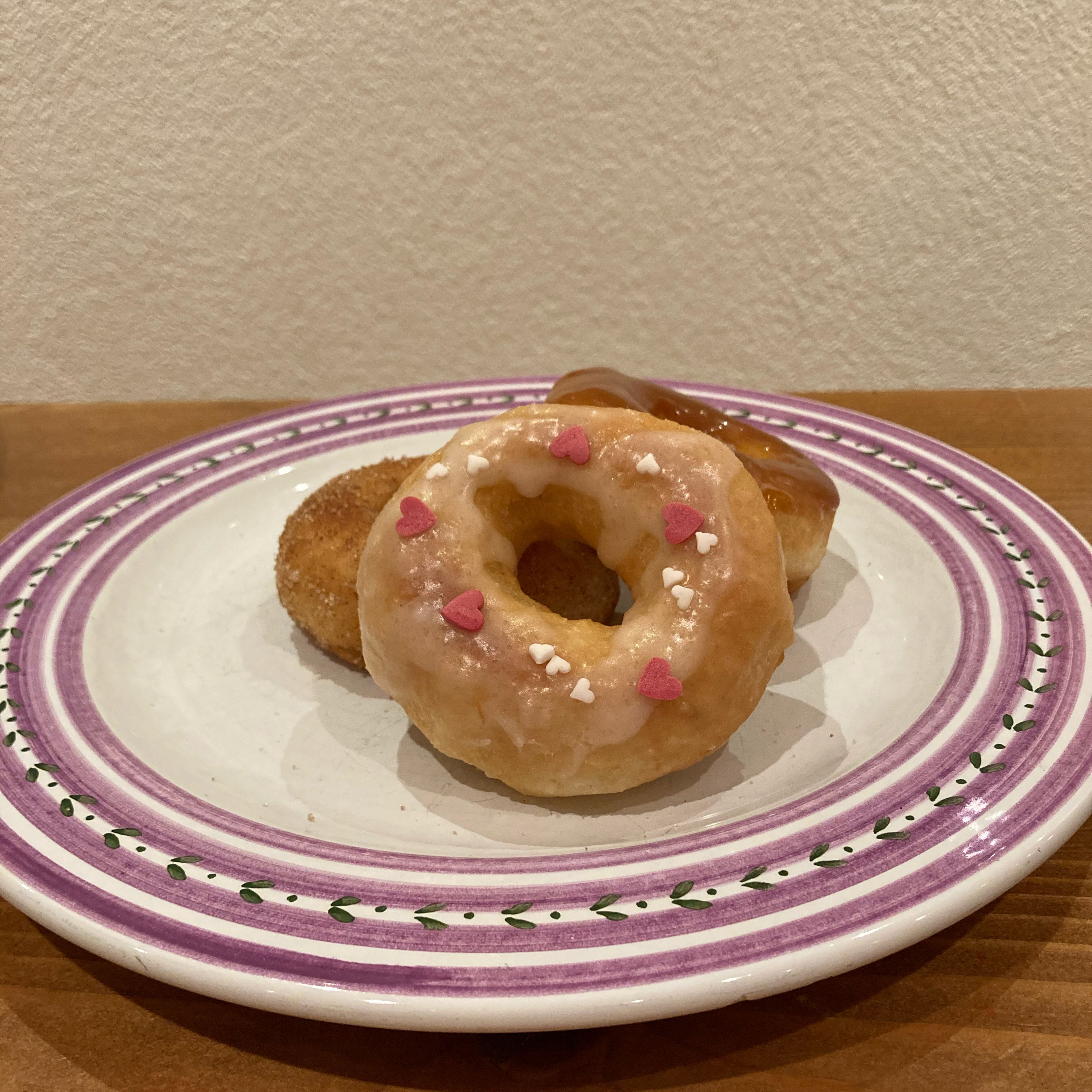 Nach der Ruhezeit das Öl in eine tiefe Pfanne geben und die Stäbchen-Probe ausführen (ein Holzstäbchen in das Öl halten, wenn sich kleine Bläschen bildet, hat es die richtige Temperatur). Die Donuts in die Pfanne geben und auf jeder Seite goldbraun backen. Am besten mit Zuckerguss oder Schokoladenglasur servieren. Bon appétit! 