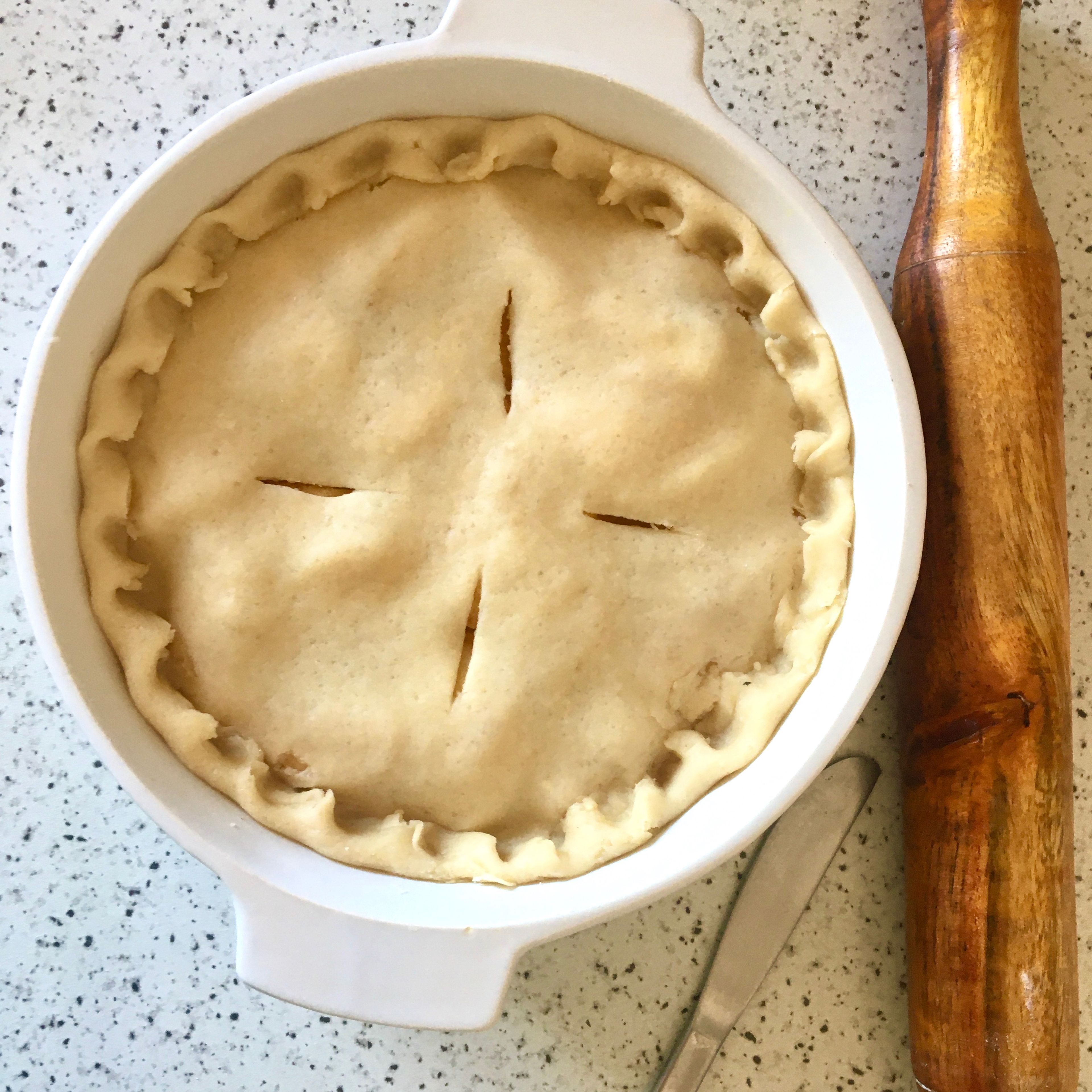 Add the apples onto the pie base, spread evenly. Roll out the remaining dough to a disc, about the size of your pie dish. Adjust it over the pie and seal the edges. Cut some scores over the top to let the steam out. Brush the surface with milk and sprinkle with sugar.