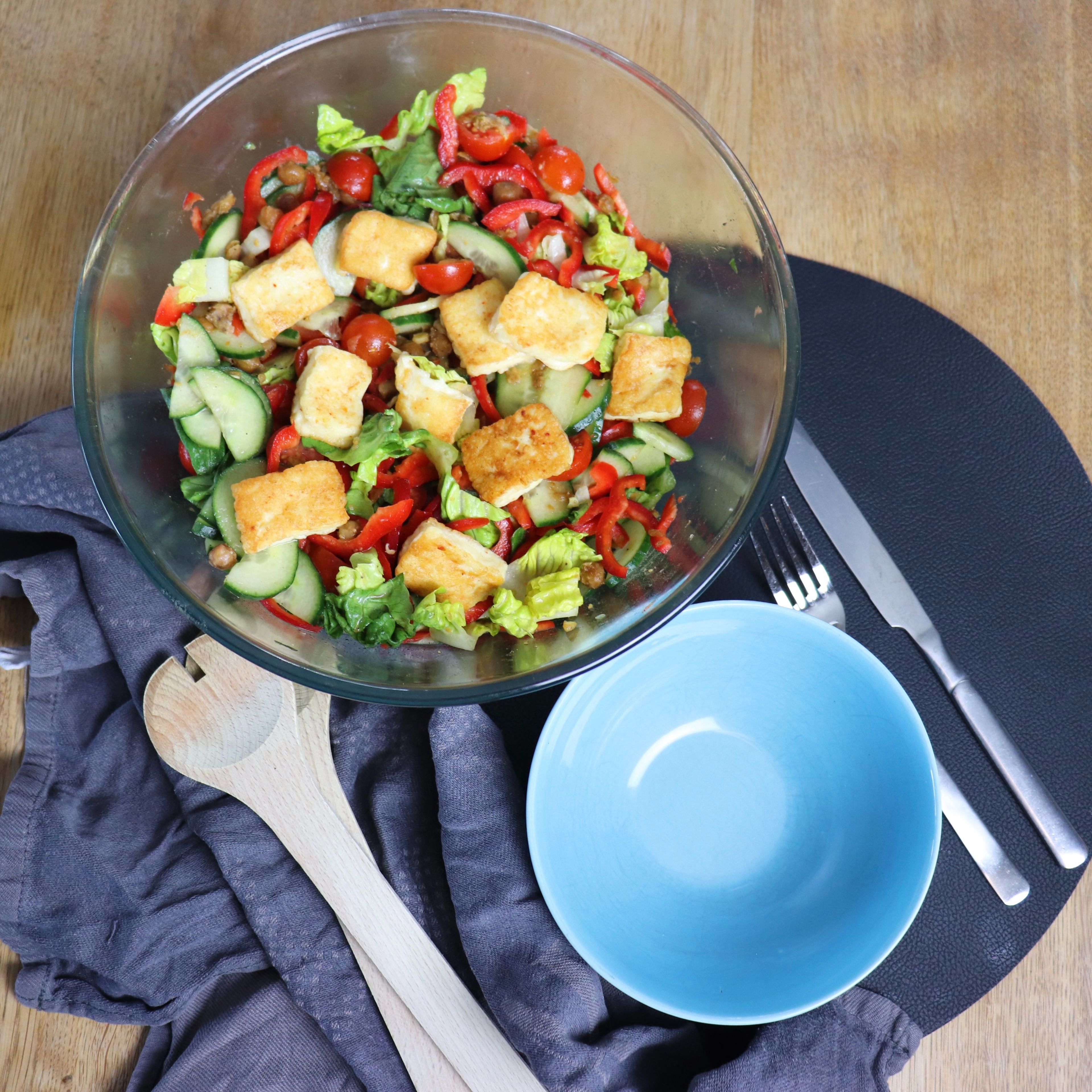Nun auch die etwas abgekühlten Kichererbsen unterrühren und den Käse auf dem Salat verteilen. Der Salat kann nun serviert werden!