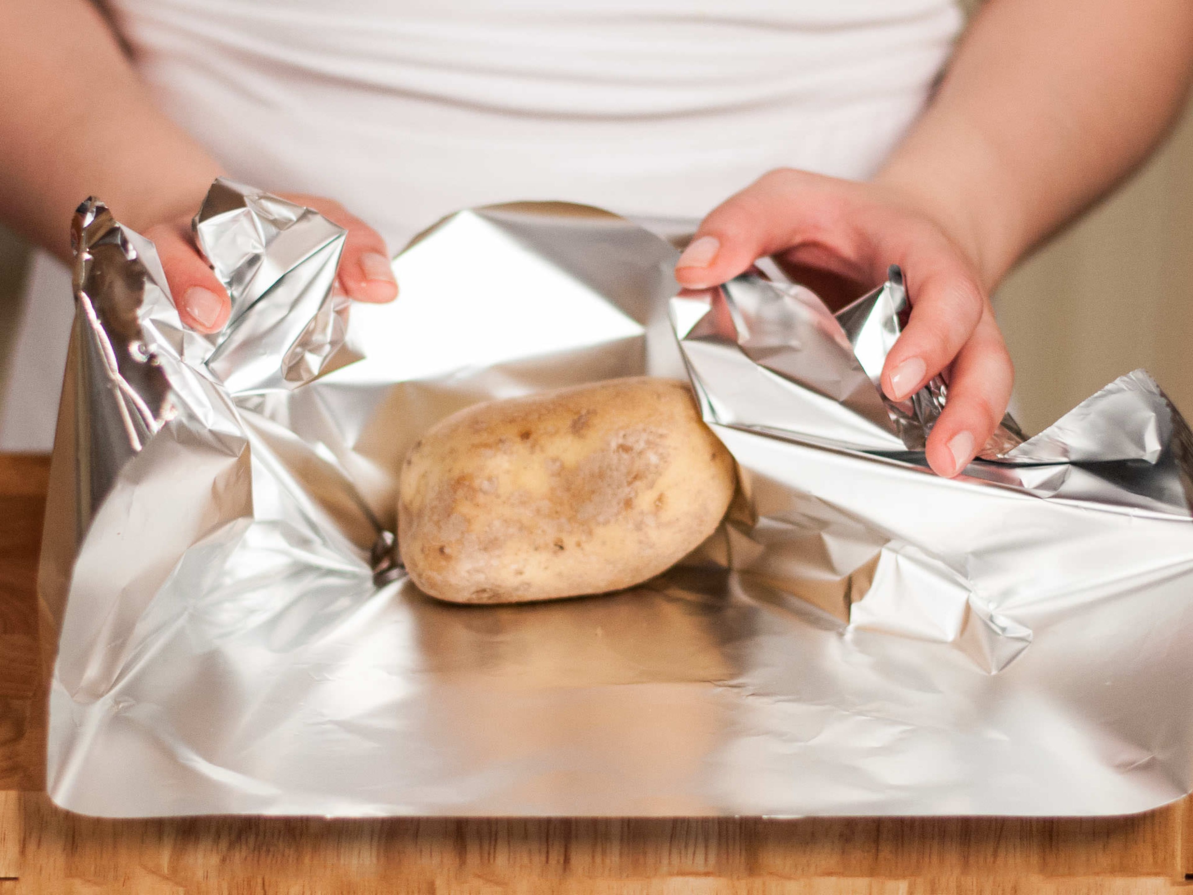Backofen auf 60°C vorheizen. Grill vorheizen. Jede Kartoffel in Alufolie einwickeln und für ca. 1 h auf den Grill legen. Alle 20 Min. drehen damit sie gleichmäßig gegart werden.