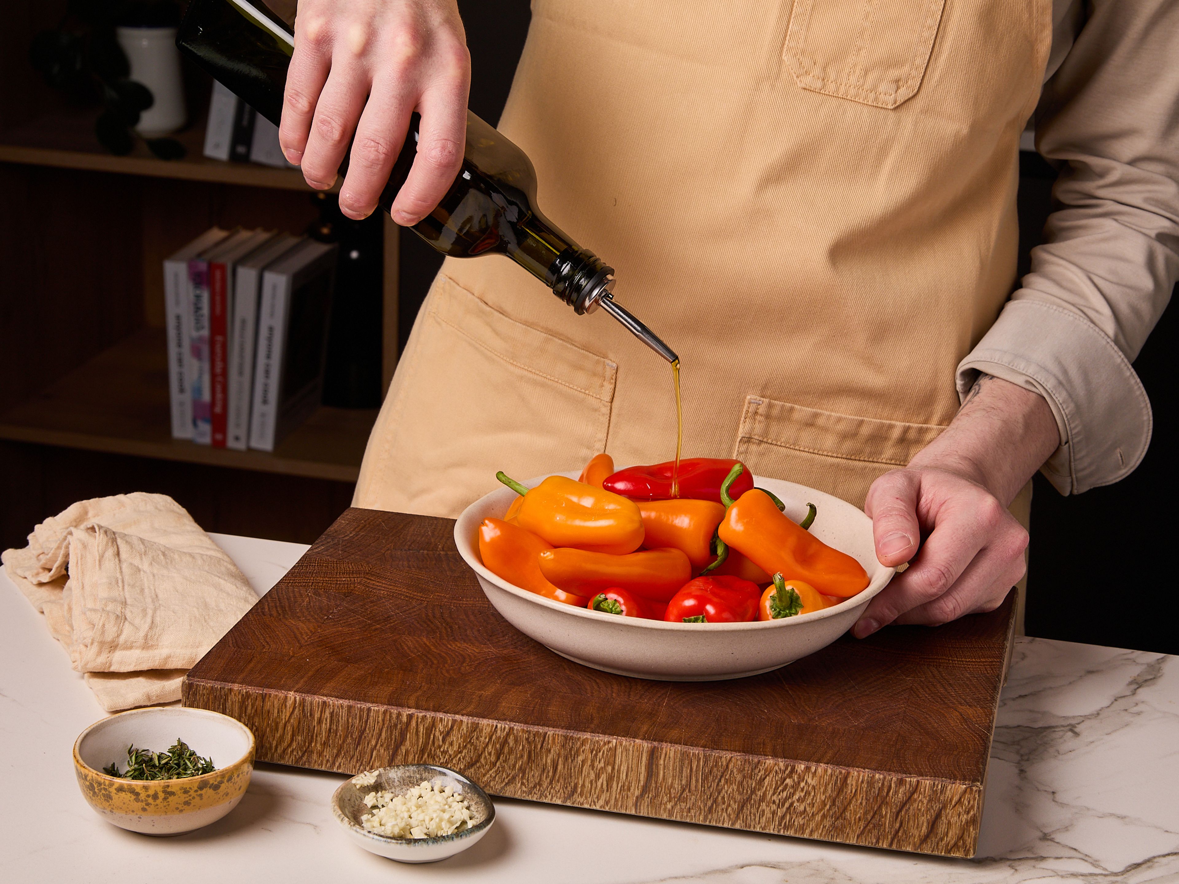 Thymian fein hacken, Knoblauch schälen und ebenfalls fein hacken. Mini-Paprika waschen, trocken tupfen und in einer Schüssel mit Olivenöl, gehacktem Thymian und Knoblauch vermengen. Mit Salz würzen und auf dem Grill oder in einer Grillpfanne ca. 5–7 Min. grillen, bis sie gebräunt und weich sind. Gegrillte Paprika in einer Schüssel beiseitestellen.